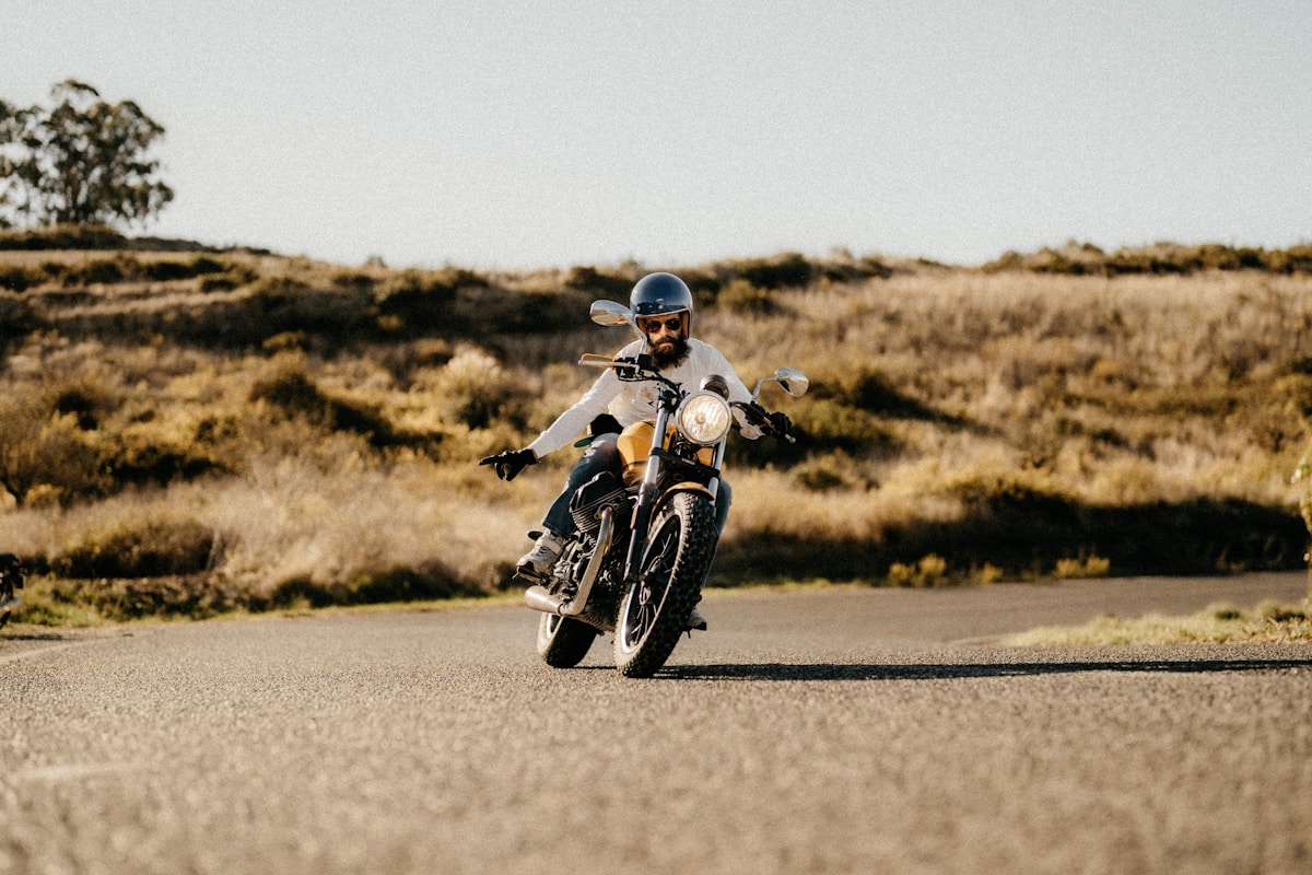 Motocycliste sur une route de campagne par une journée ensoleillée.