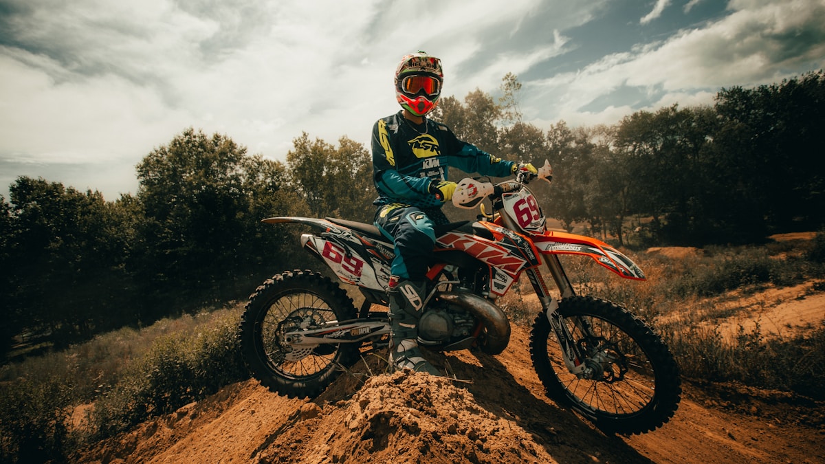 Motocycliste sur un terrain accidenté, casqué et équipé pour la course.