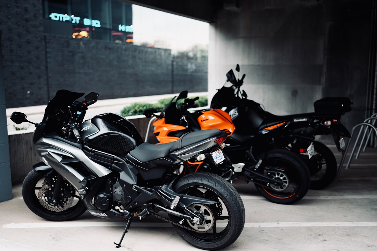 Motos de sport noires et orange garées dans un garage.