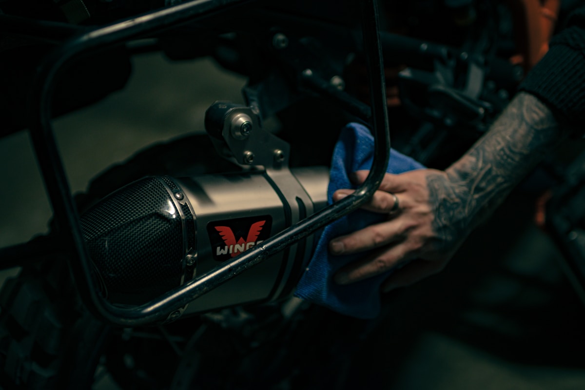 Moto avec silencieux d'échappement personnalisé et tatouage sur la main.