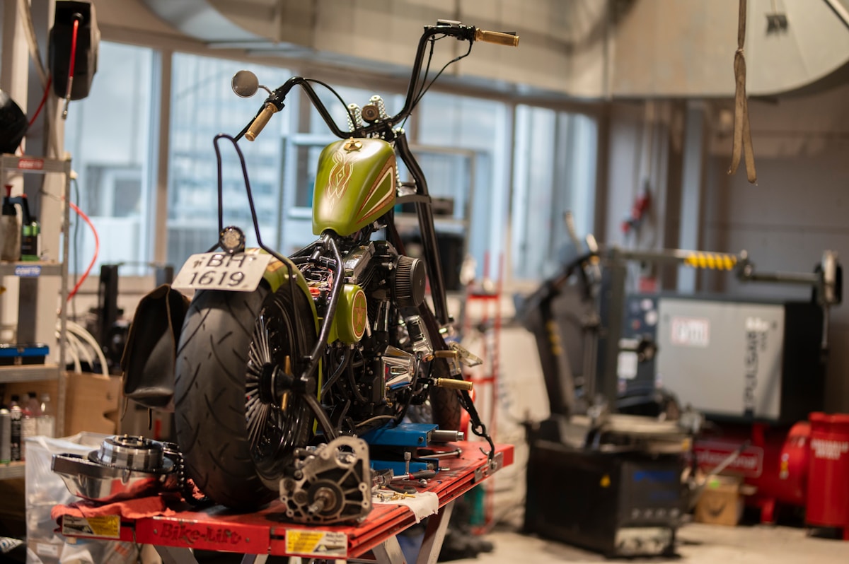 Moto personnalisée avec réservoir vert et pièces mécaniques exposées.