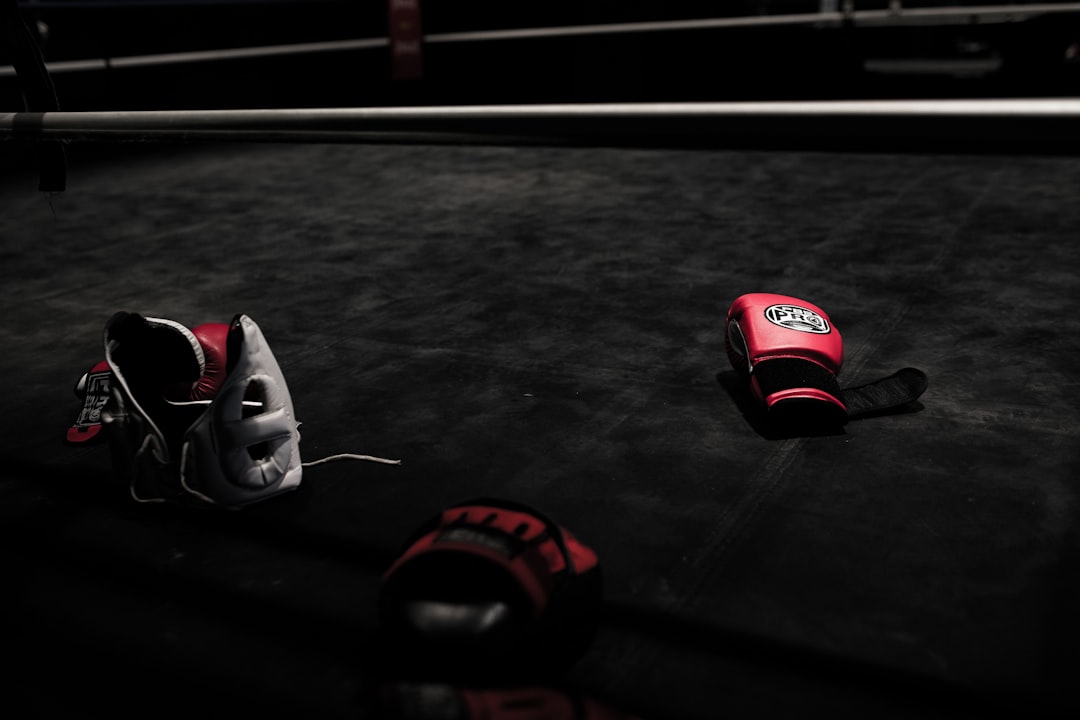 Une paire de gants de boxe rouges posée sur un banc dans un gymnase.