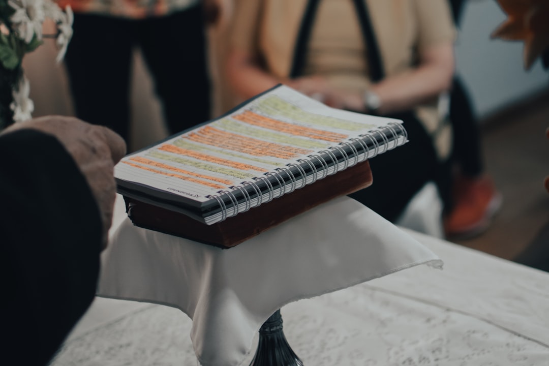 A person writing notes in a notebook during a meeting, representing personalized advice.