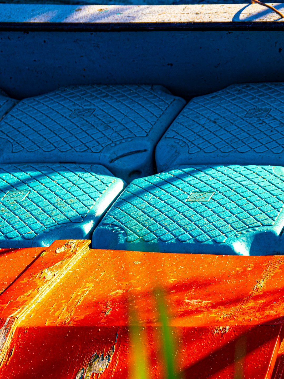 Une pile de plaids et de coussins en laine, velours et fausse fourrure dans des tons neutres, posée sur un canapé.