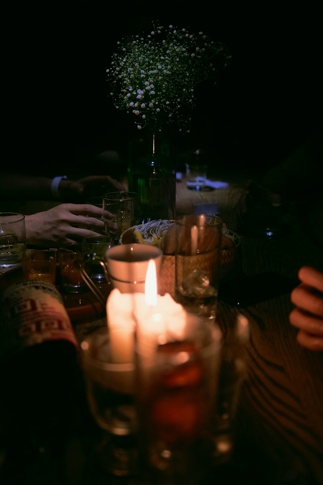 Un groupe d'amis partageant joyeusement une planche de charcuterie et de fromage avec des verres de vin dans un bar à vin confortable et faiblement éclairé.