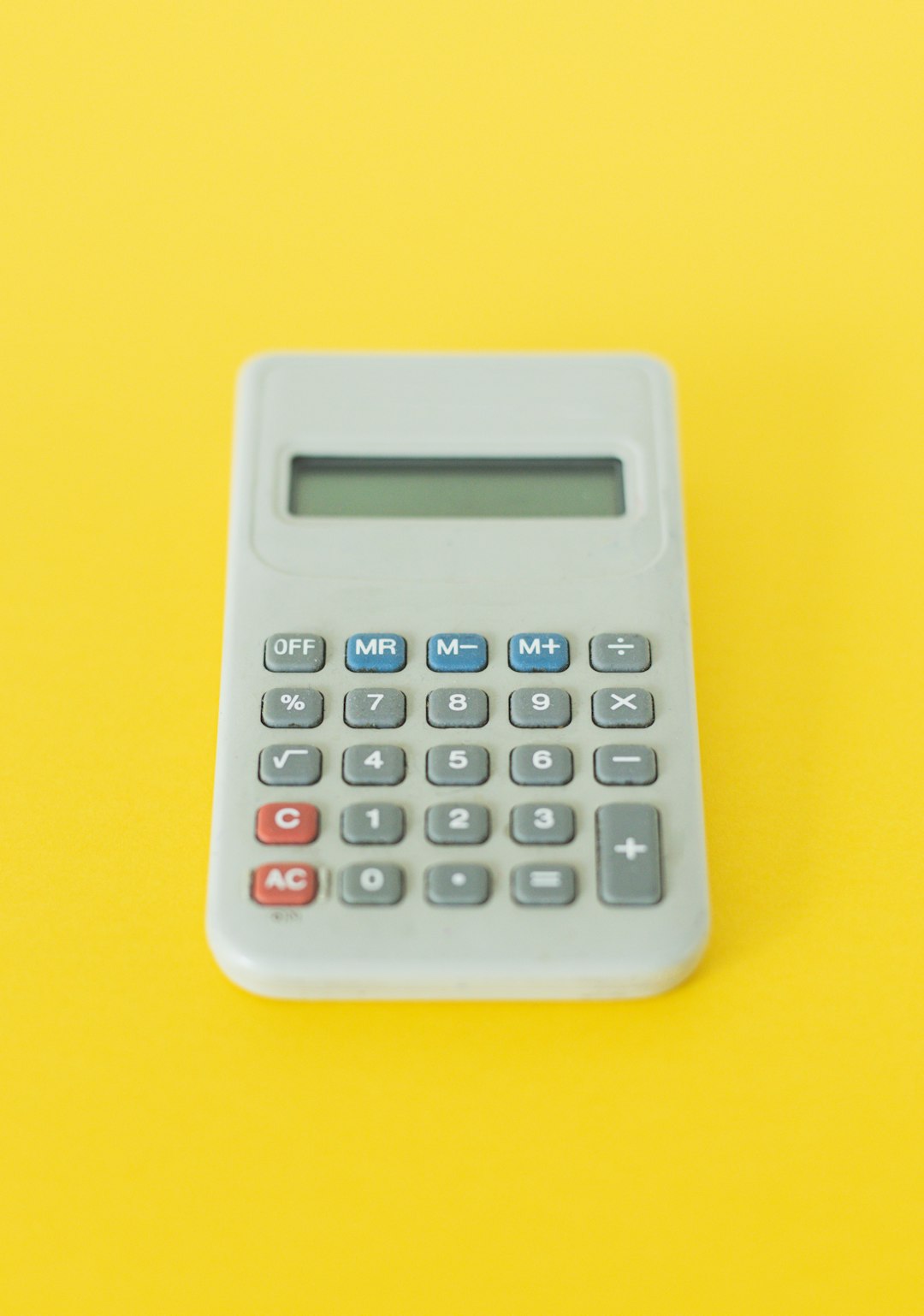 Someone using a calculator with stacks of coins and business charts behind them, symbolizing how automation helps with cost savings and smart financial planning.