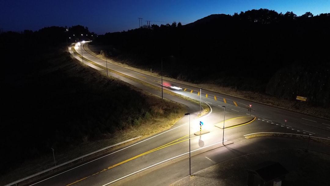An aerial shot of a crazy highway interchange at night, with car light trails showing how you can handle complicated, large-scale content strategies with total precision and efficiency.