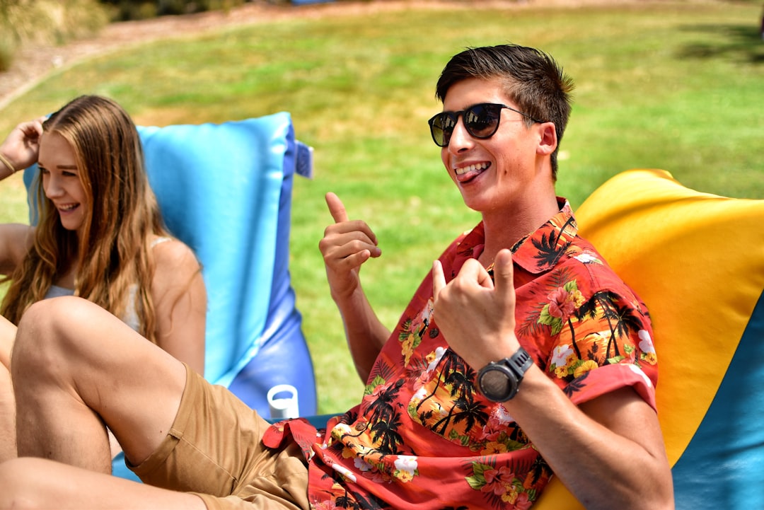 Des amis rient et trinquent avec des bouteilles de Grano Maté dans un cadre de bar urbain et branché. La lumière est chaude et l'ambiance est conviviale et détendue.