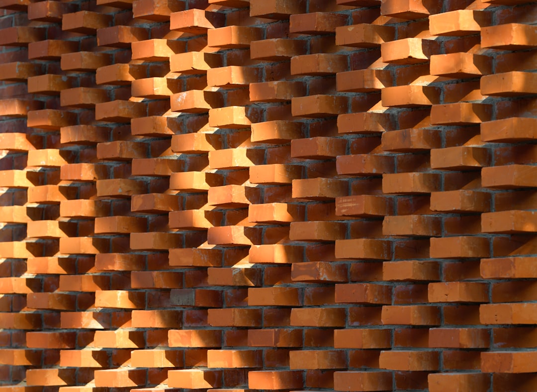 Un mur texturé peint en terracotta, servant de toile de fond à des poteries et des plantes vertes.