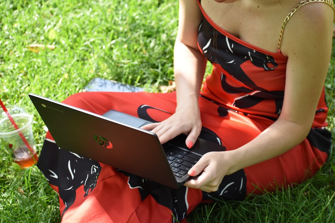 Une femme assise devant son ordinateur portable, participant à une visioconférence dans un cadre confortable et lumineux.