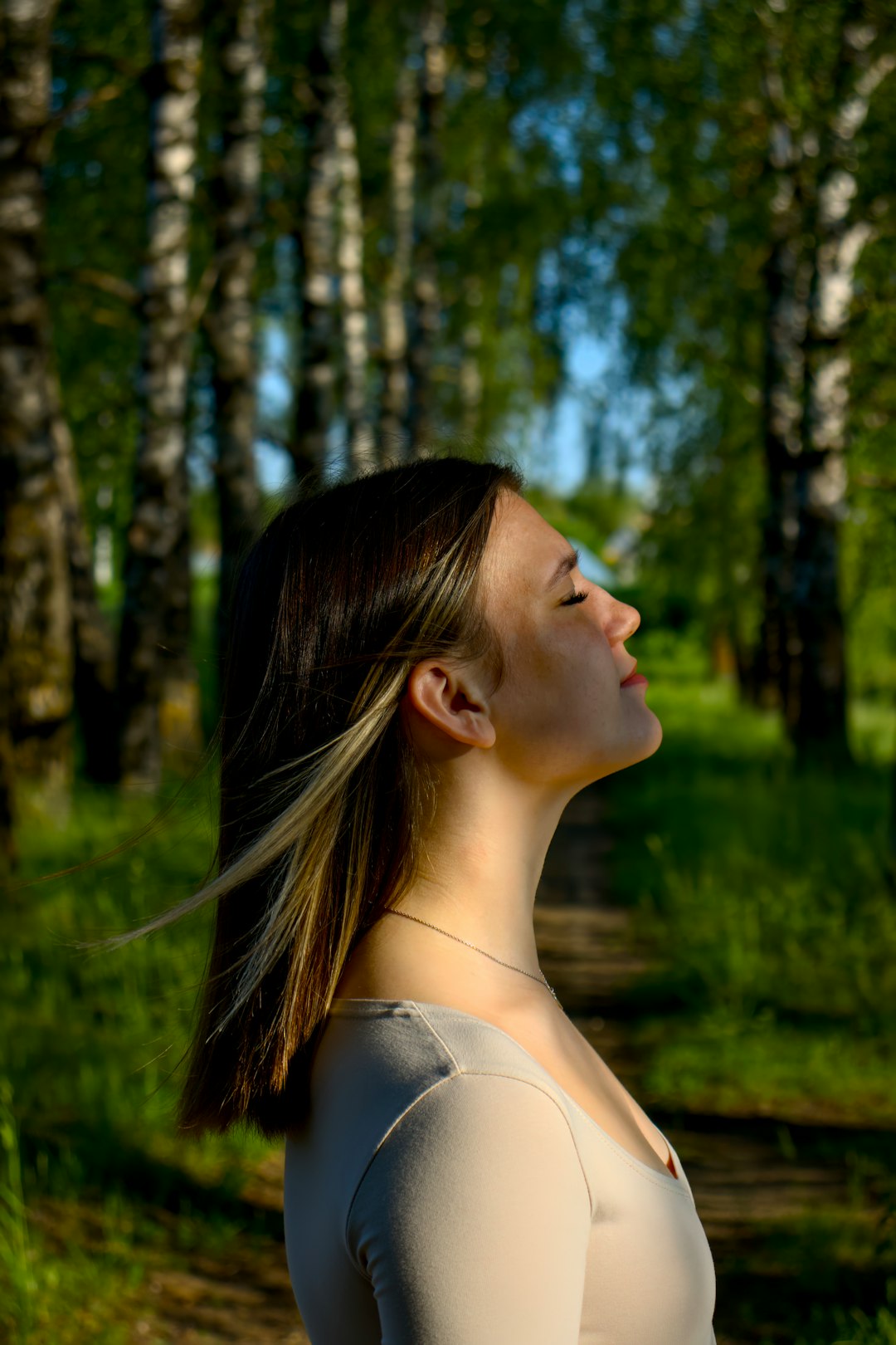 Une femme méditant paisiblement dans un environnement naturel, les mains en position de réception d'énergie.