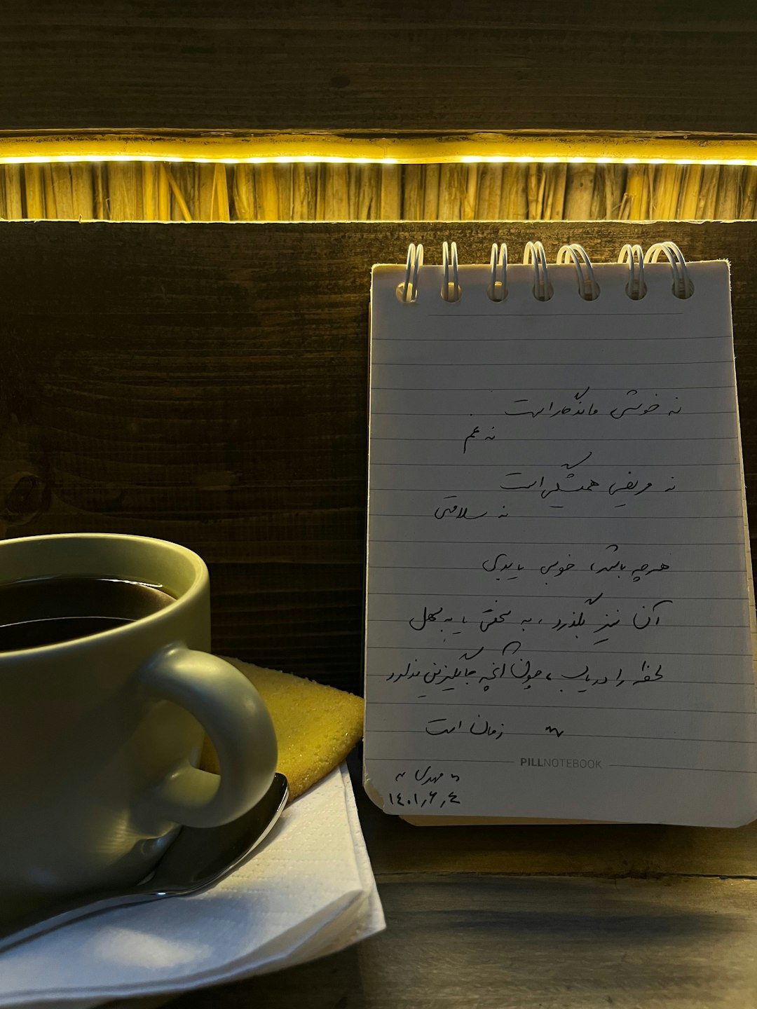 Une personne qui écrit dans son journal, une tasse de thé à côté : l'image parfaite du développement personnel et de l'introspection.