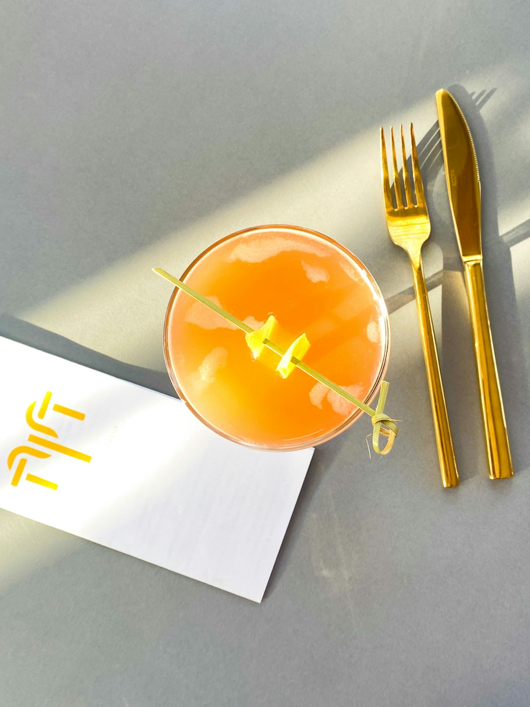 Un menu de restaurant à la fois rustique et chic, posé sur une table en bois. On remarque tout de suite la police d'écriture élégante et le petit logo personnalisé en haut, qui fait toute la différence.