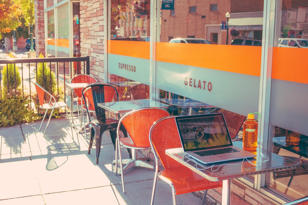 A freelancer working on a laptop in a bright, creative cafe setting, looking focused and inspired.