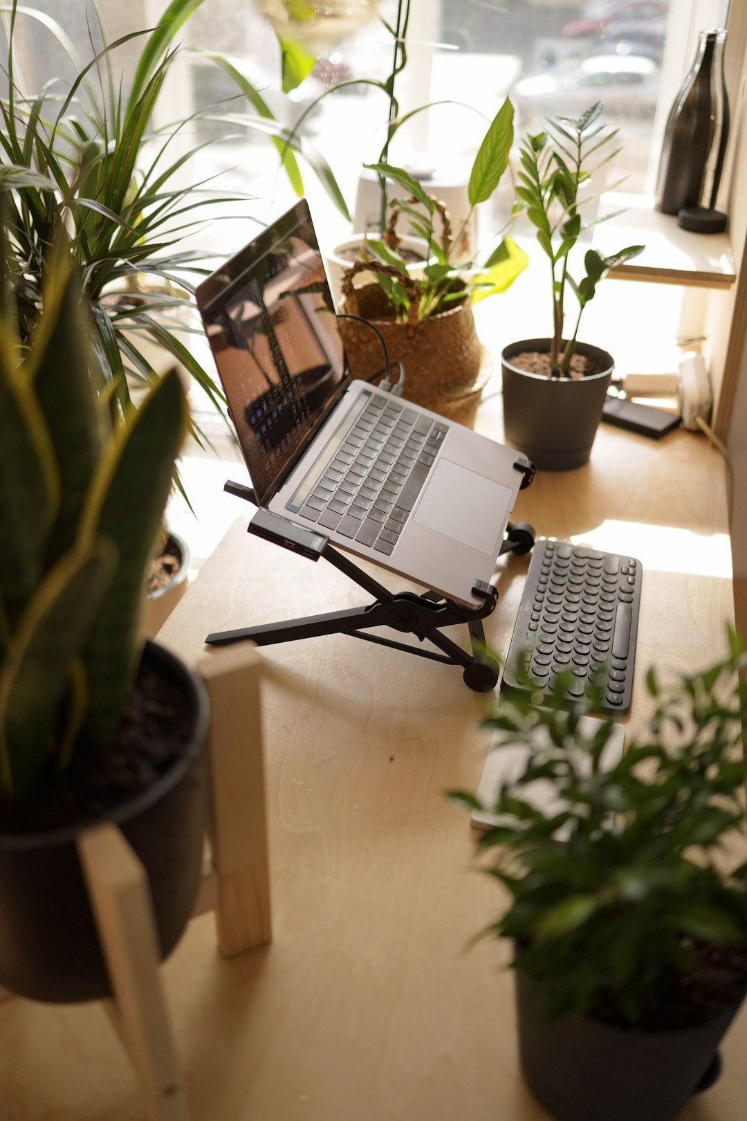 Vue d'un bureau bien organisé avec un ordinateur portable, un carnet et une plante, évoquant l'efficacité et le professionnalisme.