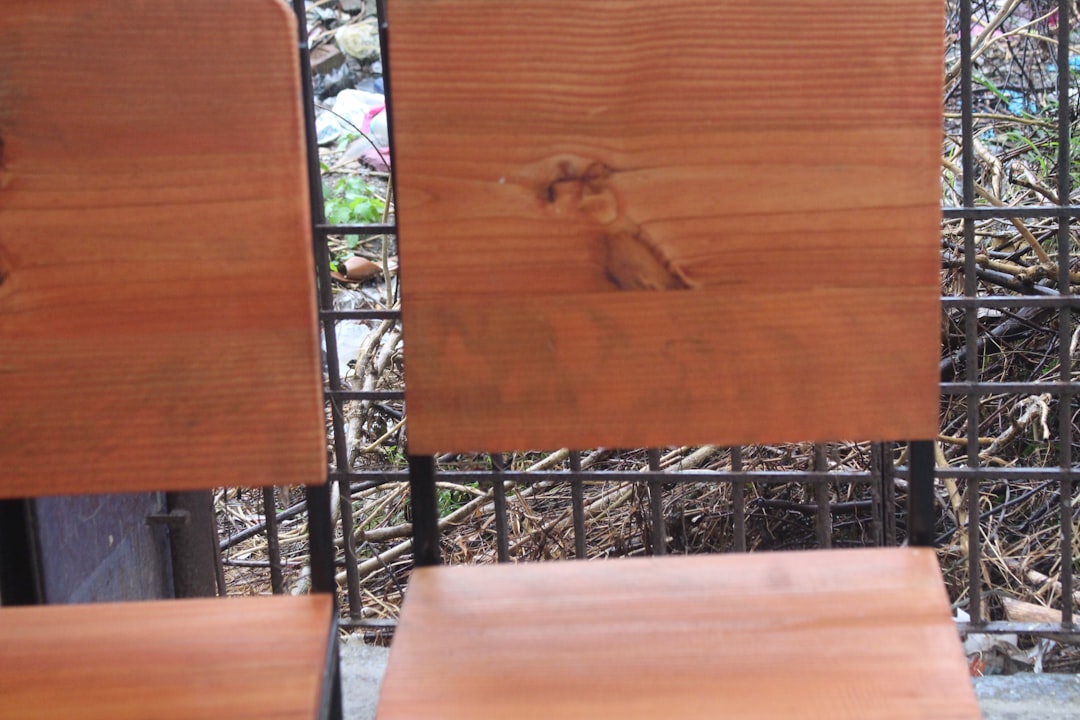 Une suspension design en laiton avec plusieurs globes en verre opalin, suspendue au-dessus d'une table à manger en bois sombre. Photo de Beazy sur Unsplash