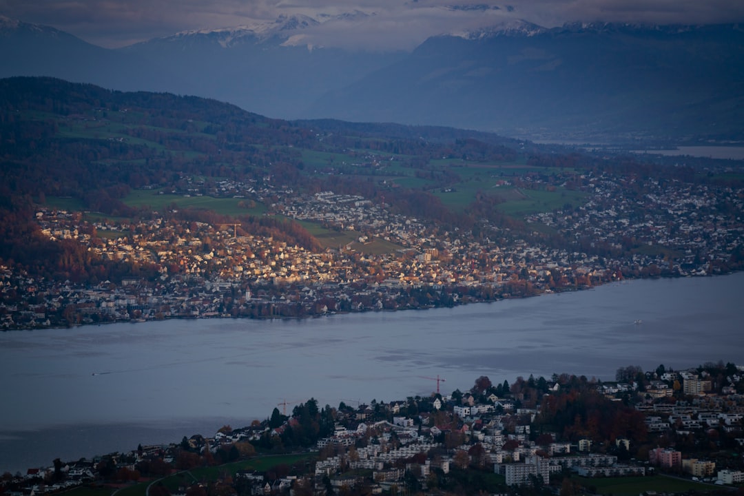 Vue aérienne d'une ville suisse comme Genève ou Zurich, avec son lac et ses bâtiments, pour illustrer l'importance de la connaissance locale.