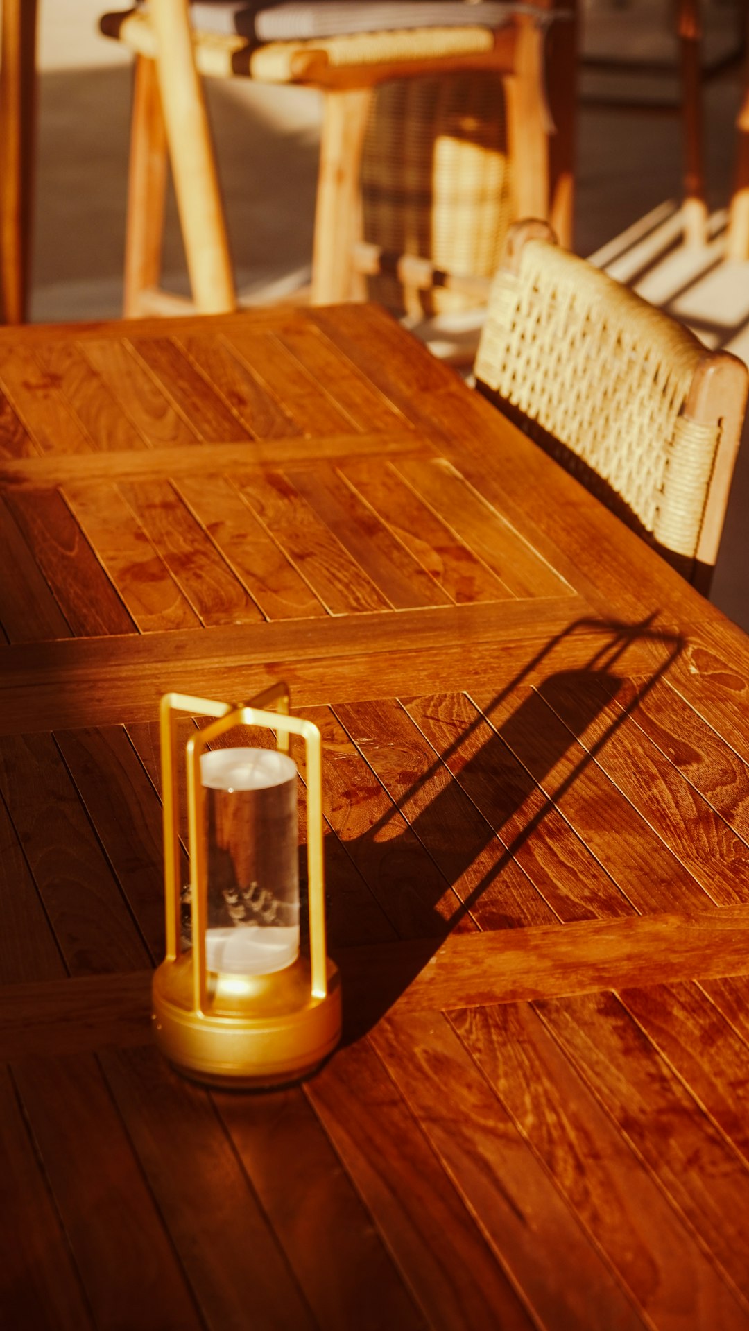 Un gros plan sur un appareil photo hybride noir moderne posé sur une table en bois, la lumière mettant en valeur ses détails.