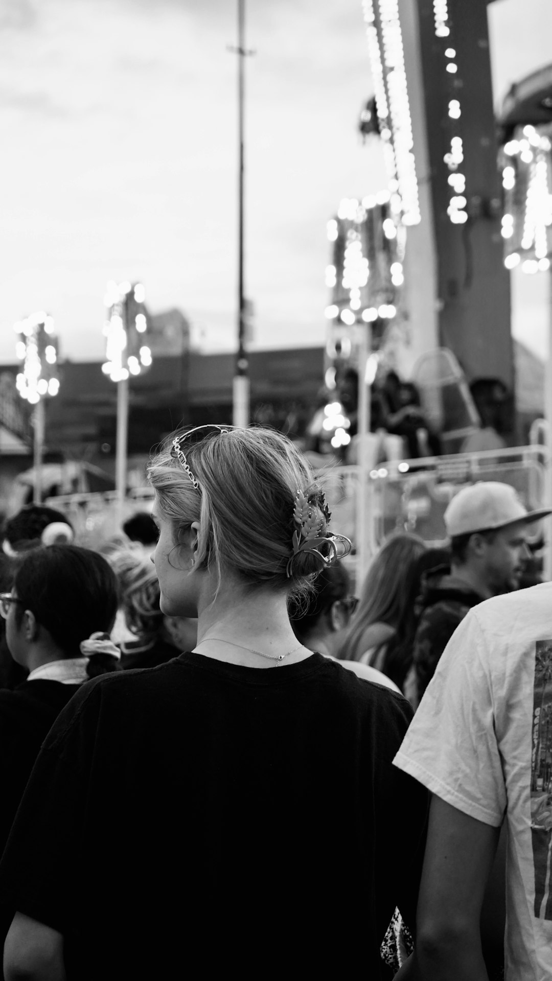 A diverse crowd of people smiling and watching a performance, with the focus on their engaged faces. The lighting is warm and inviting.