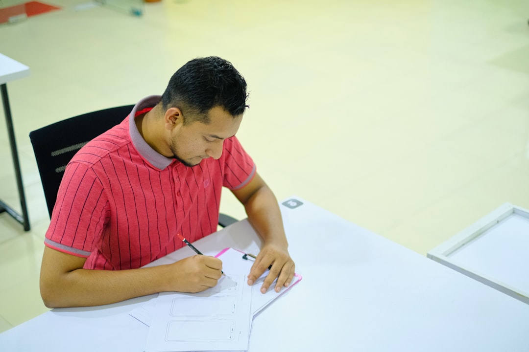 Une personne signant un document sur un bureau bien organisé avec une plante, évoquant un service professionnel et personnalisé.