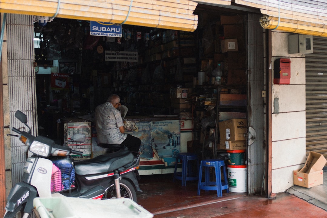 A small business owner working at a counter in their bright, welcoming shop, focused on their laptop.