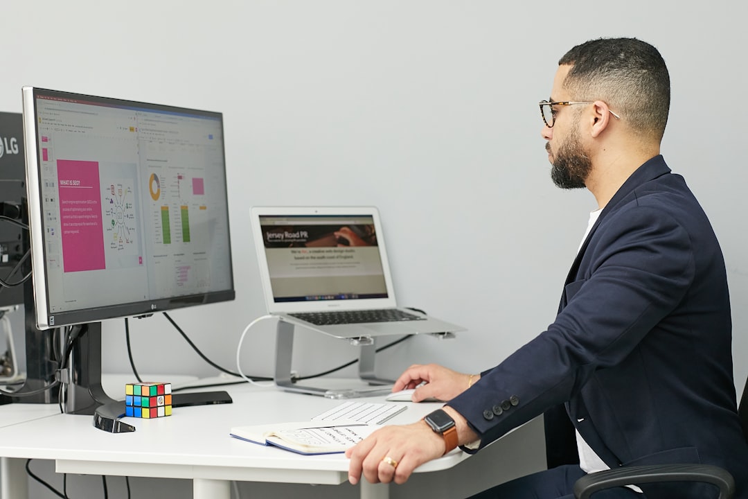 A shot of a business pro at a slick desk with multiple screens, checking out data charts and network graphs. It's the perfect symbol of human oversight on automated systems.