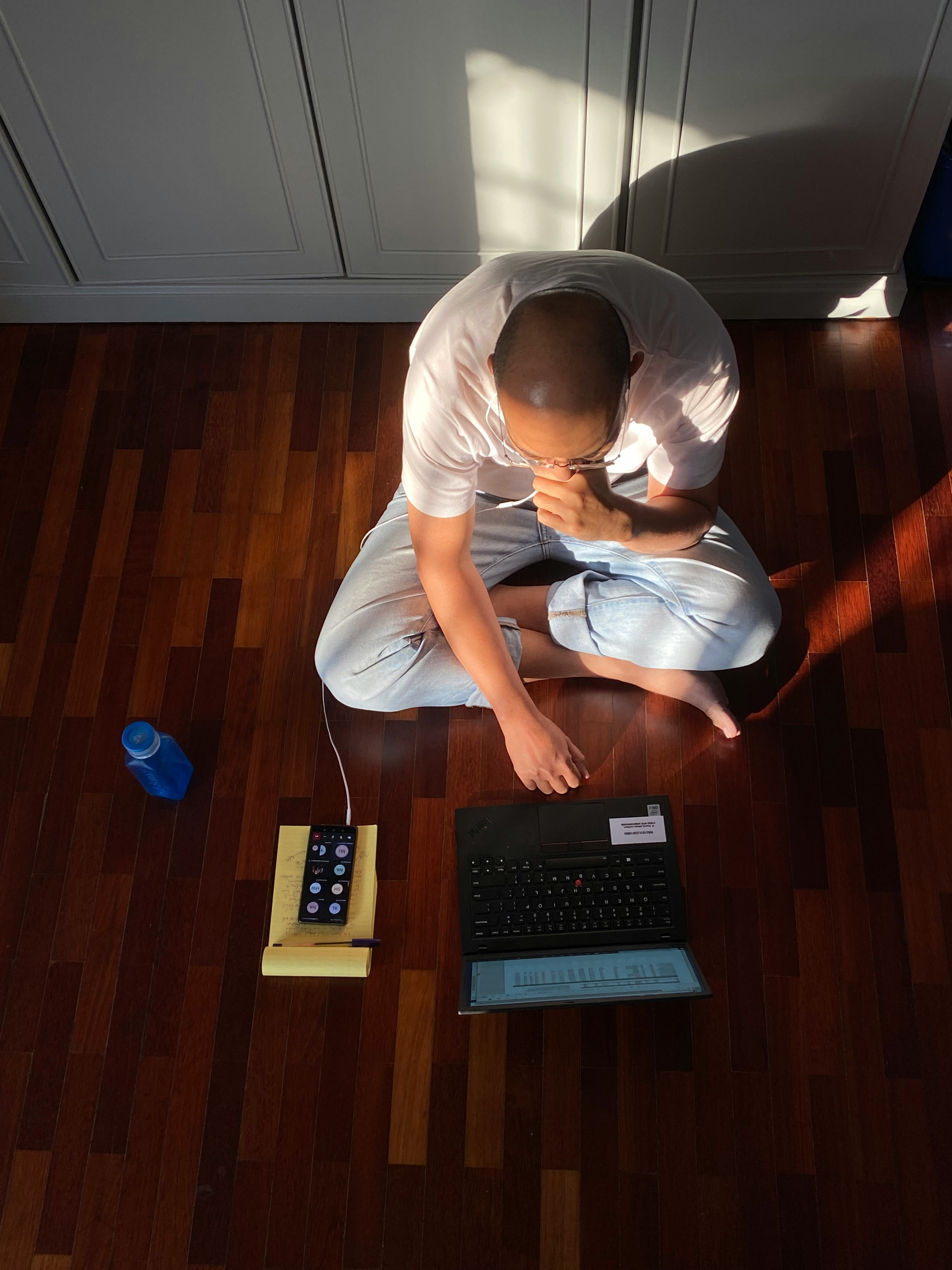 Someone sitting at a clean desk with a laptop and notepad, deep in thought while looking at the screen—the perfect image of the planning and review part of creating content.
