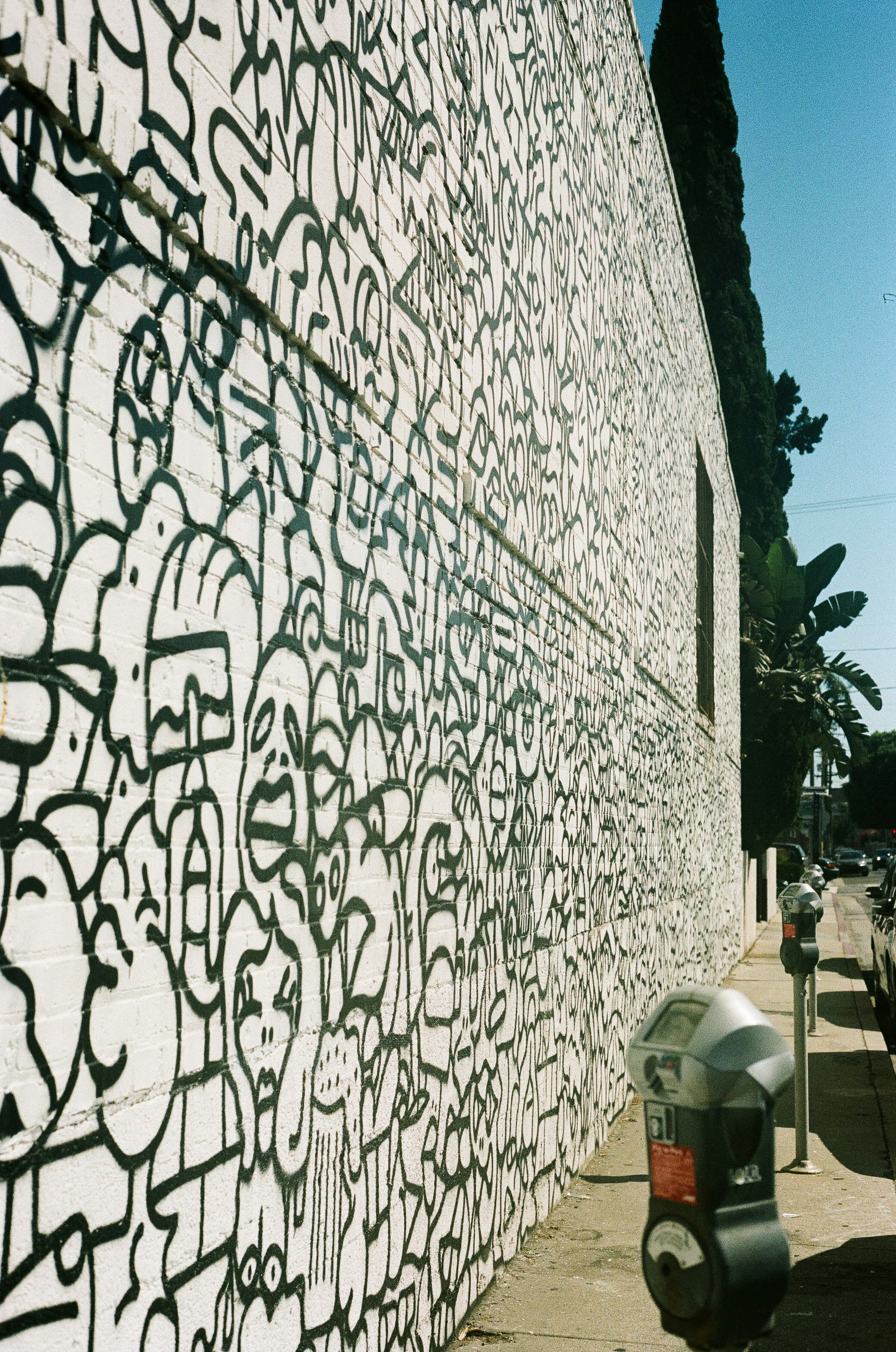 Une main de peintre utilisant un ruban de masquage pour protéger les bords d'un mur avant de peindre, démontrant le soin et la précision du travail.