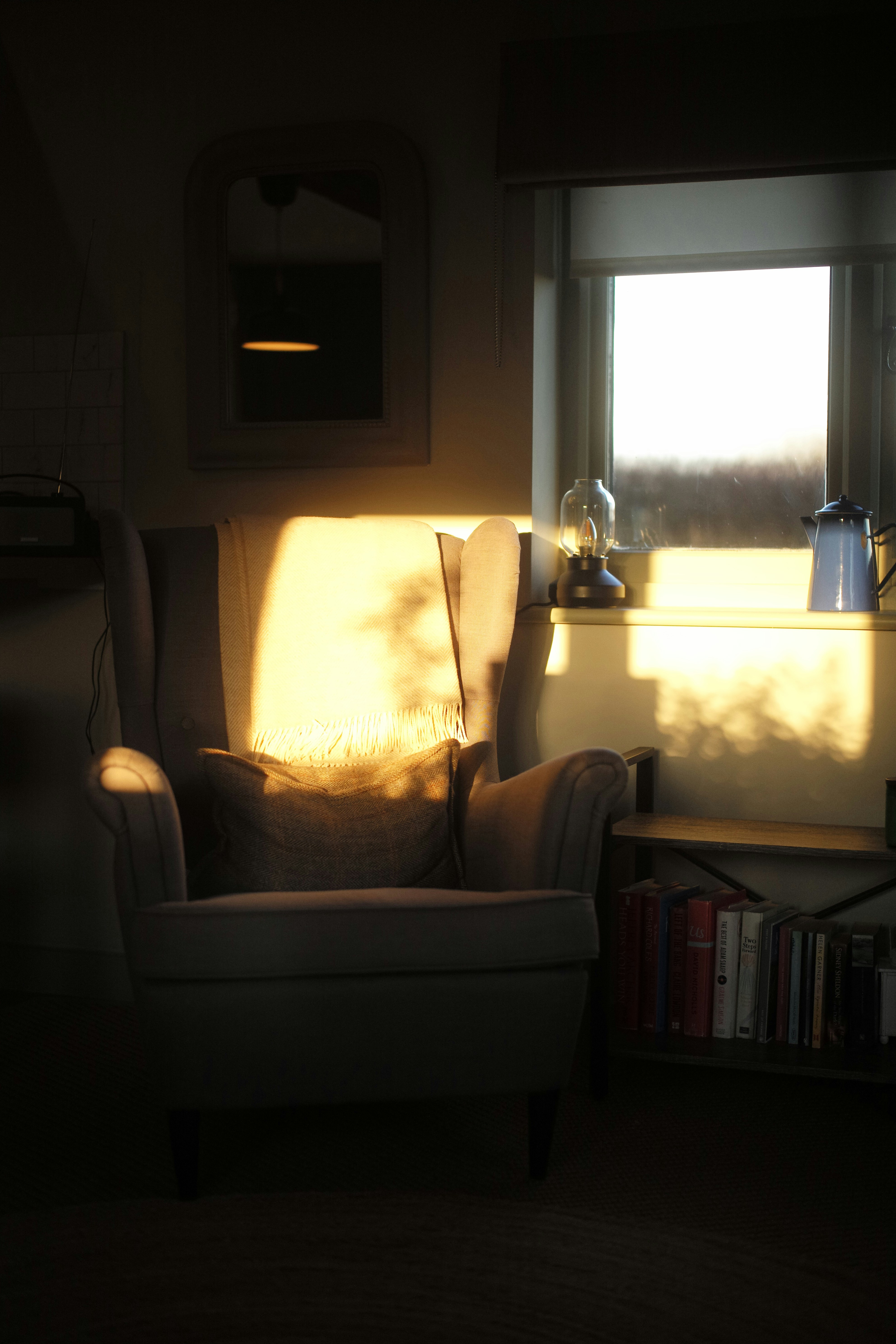 Un intérieur de salon avec plusieurs sources de lumière : une lampe sur pied, une lampe de table et des spots au plafond, créant une ambiance chaleureuse.