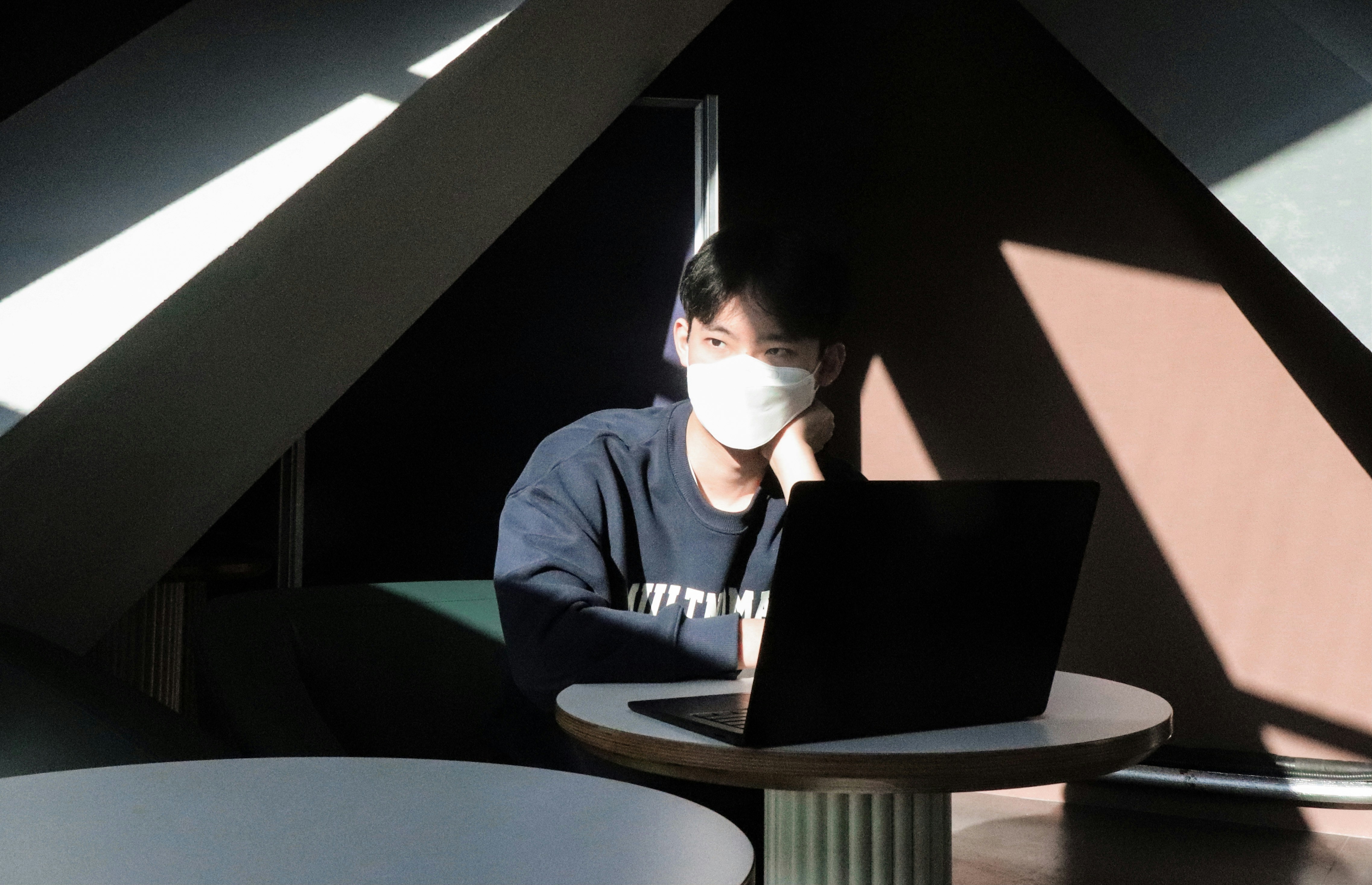 Une personne absorbée par son travail sur un ordinateur portable dans un bureau paisible, image de l'efficacité et de la concentration.