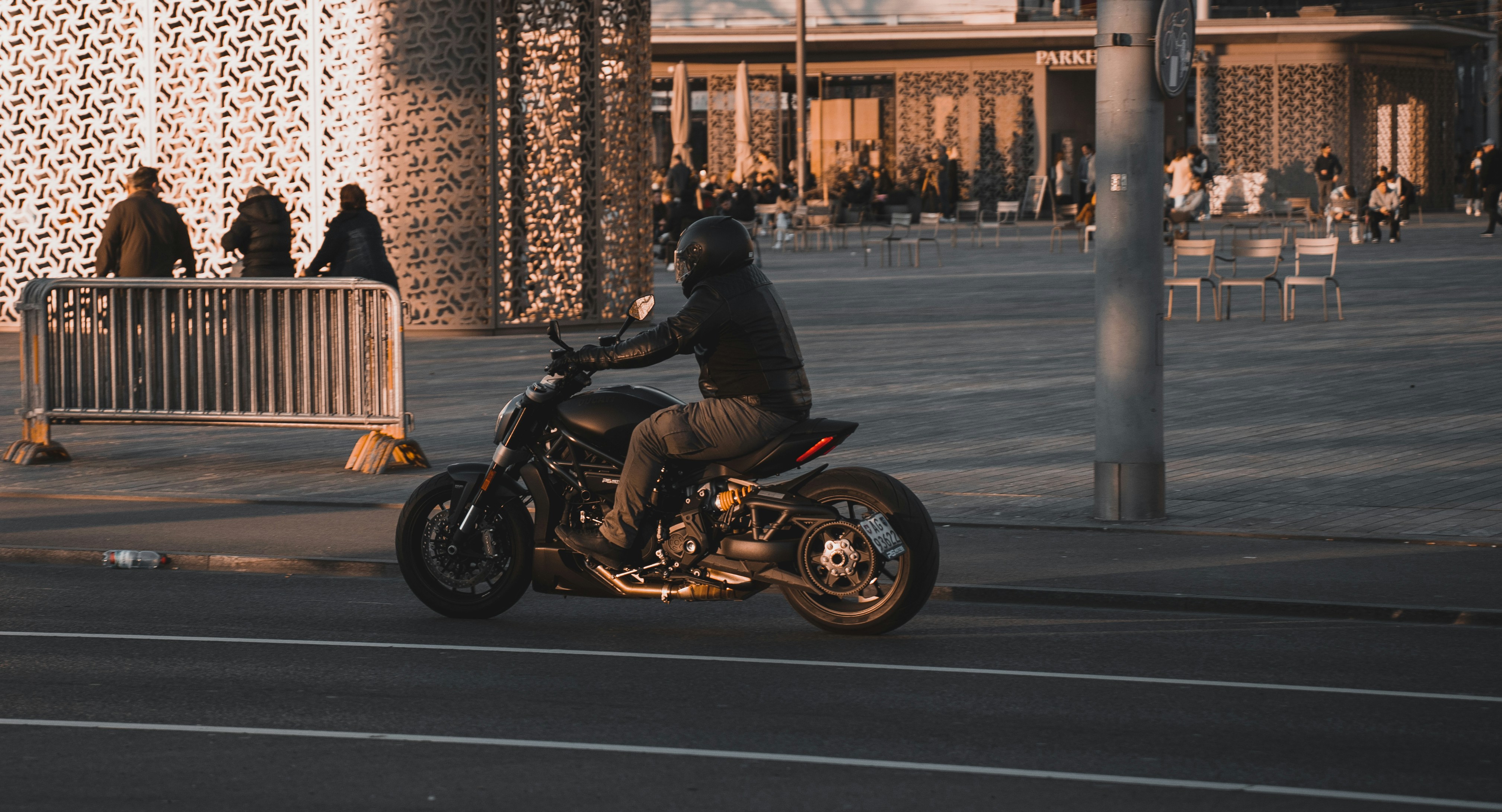 Une moto de style américain garée devant un bâtiment en bois au coucher du soleil, évoquant la liberté et l'aventure.
