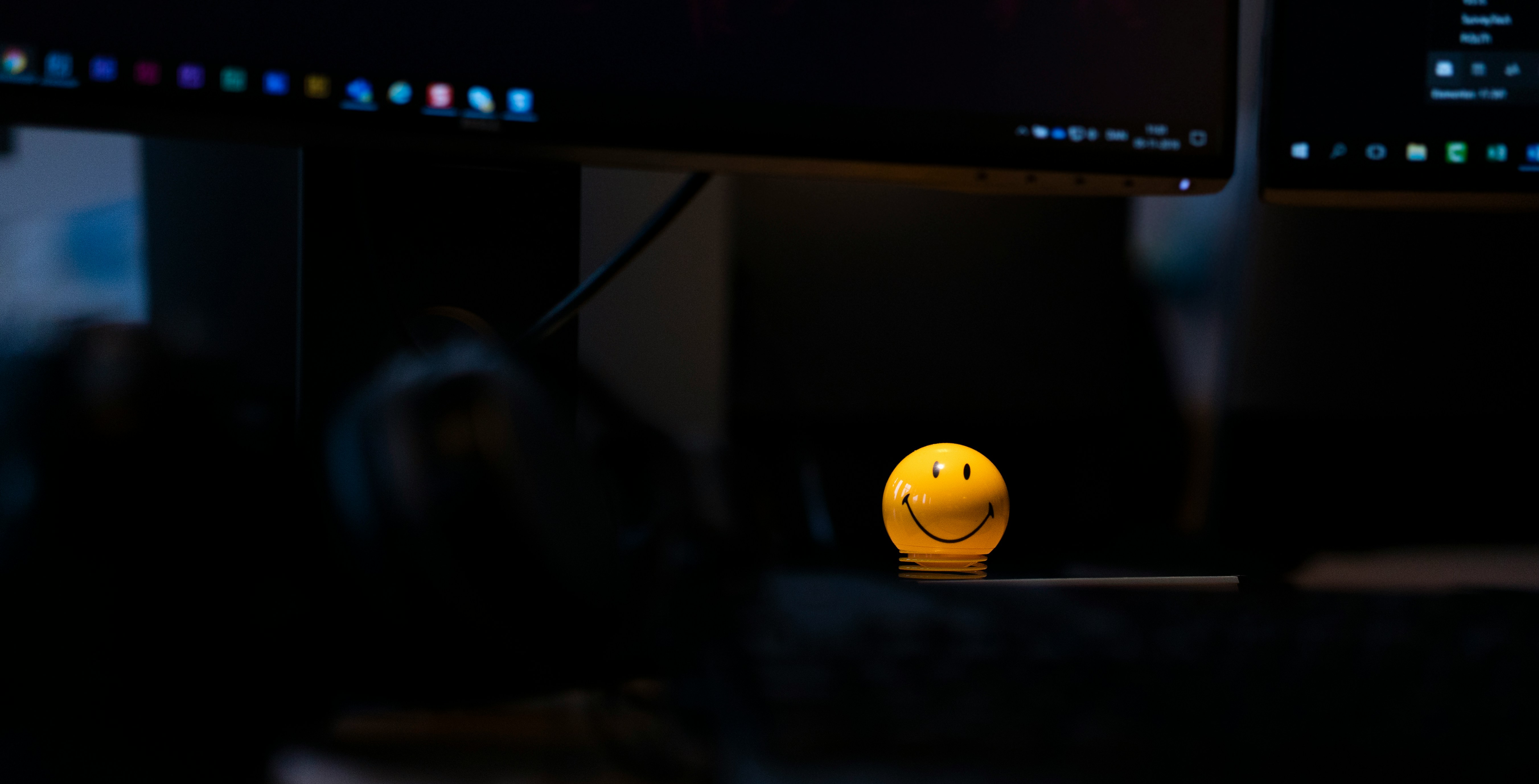 Une personne souriante tenant une tablette et interagissant avec un client lors d'une visioconférence, symbolisant un support client proactif et la fidélisation.