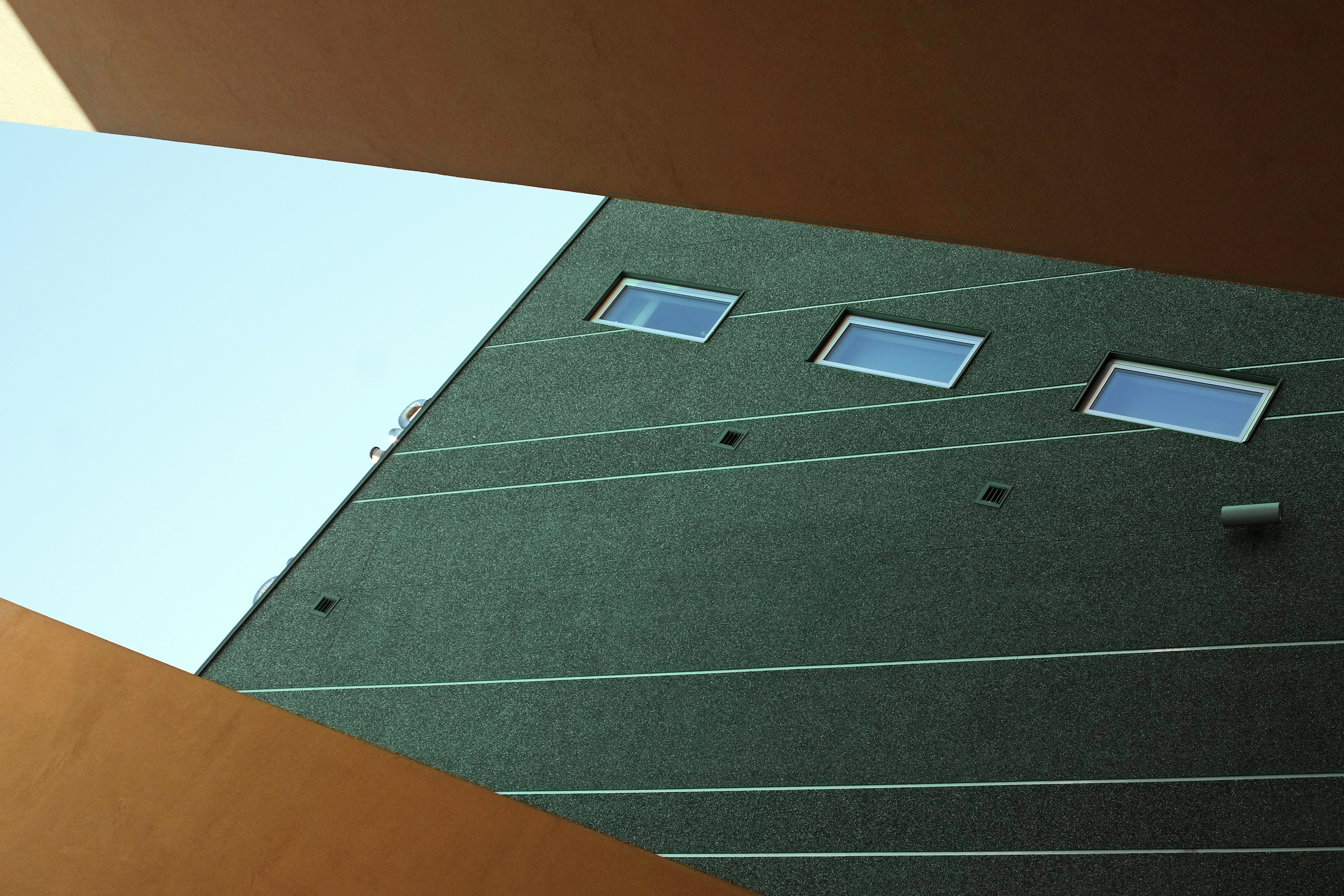 Un ruban à mesurer posé contre un mur non peint, symbolisant la phase de planification et de mesure d'un projet de rénovation.