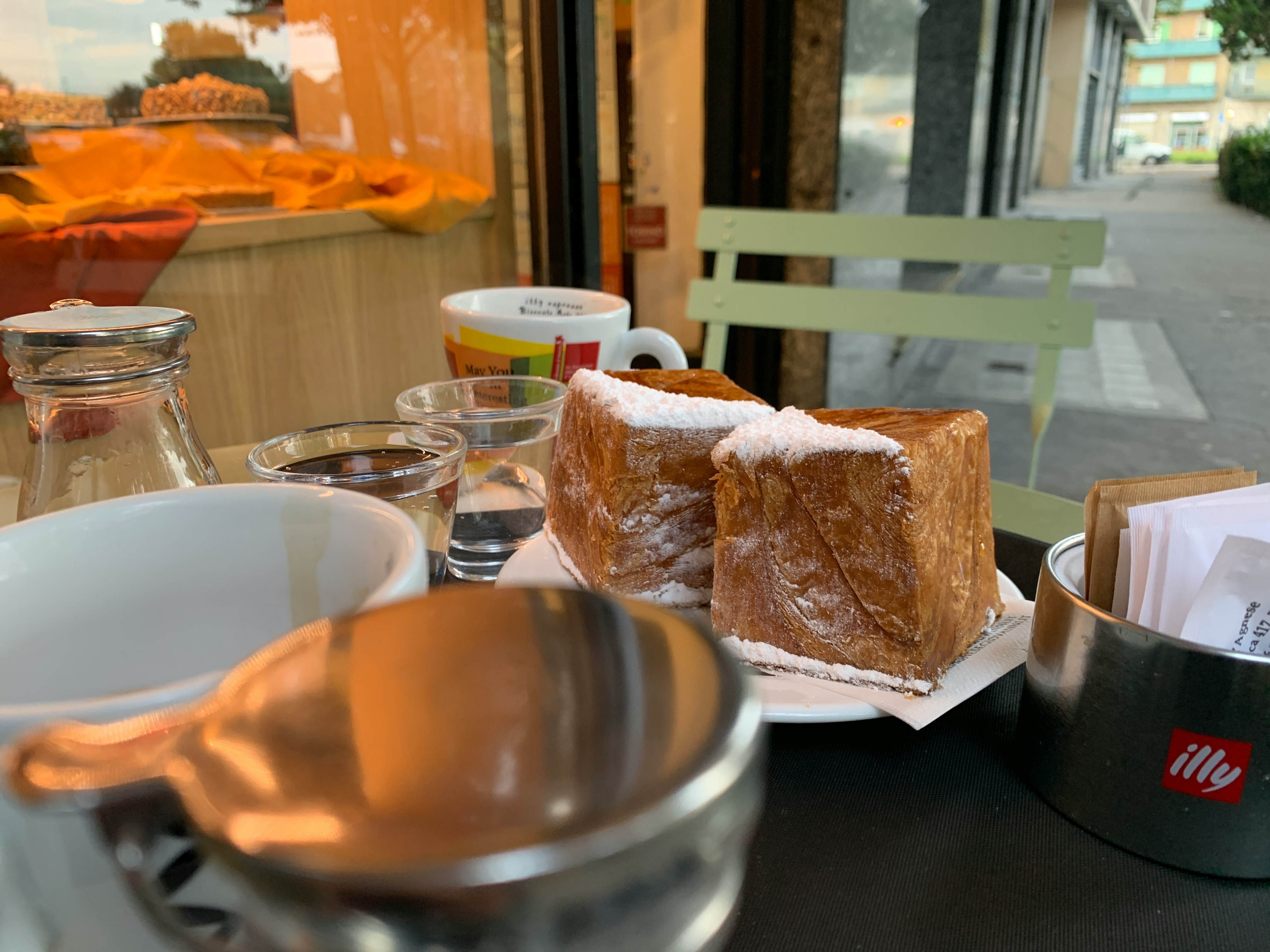 Une fondue au fromage bouillonnante dans son caquelon au centre d'une table, entourée de morceaux de pain.