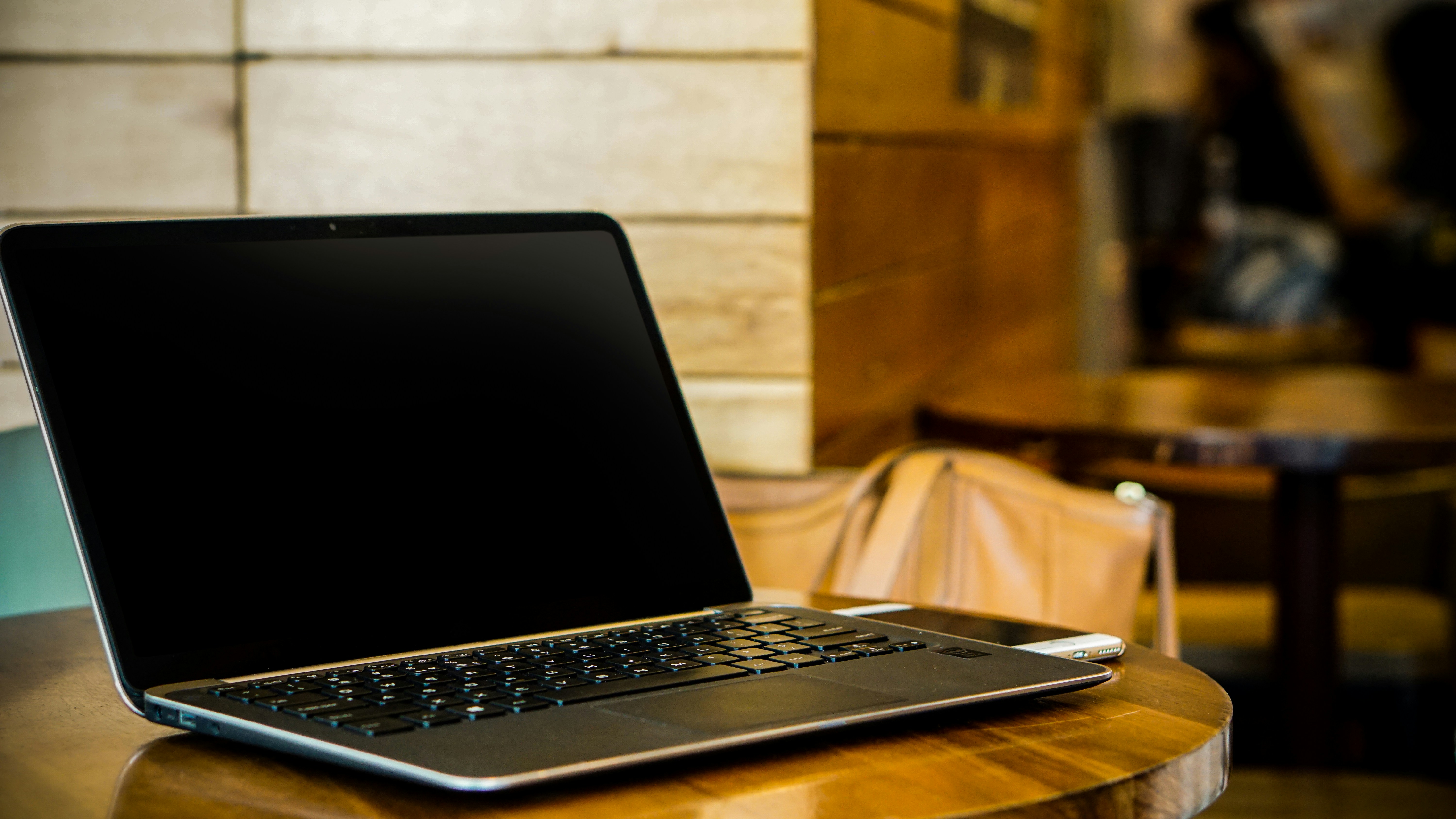 A proud small business owner standing in their shop with a laptop on the counter, showing off their new website.