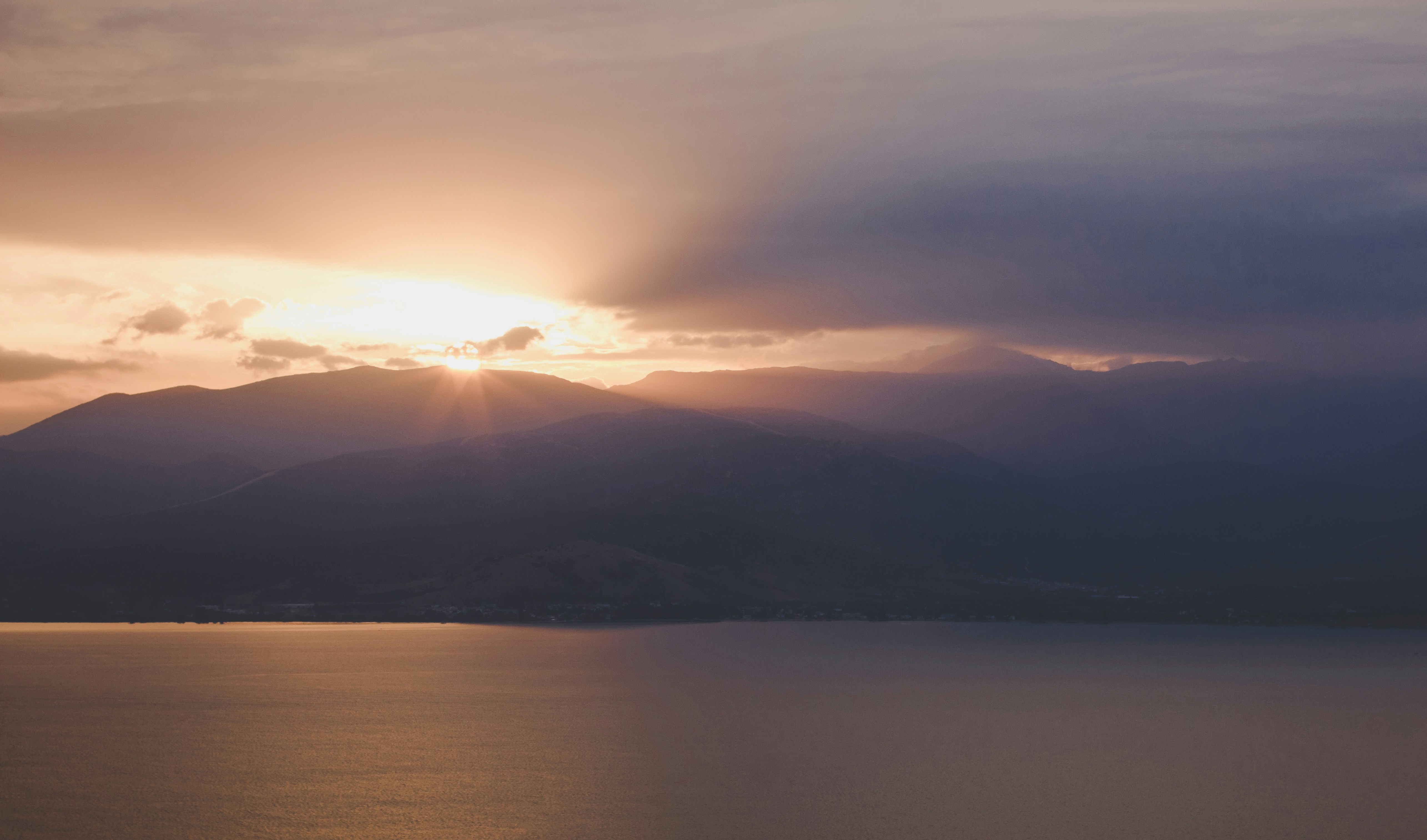 Une vue panoramique de Lausanne et du lac Léman au coucher du soleil, soulignant le lien de l'agence avec la région romande.