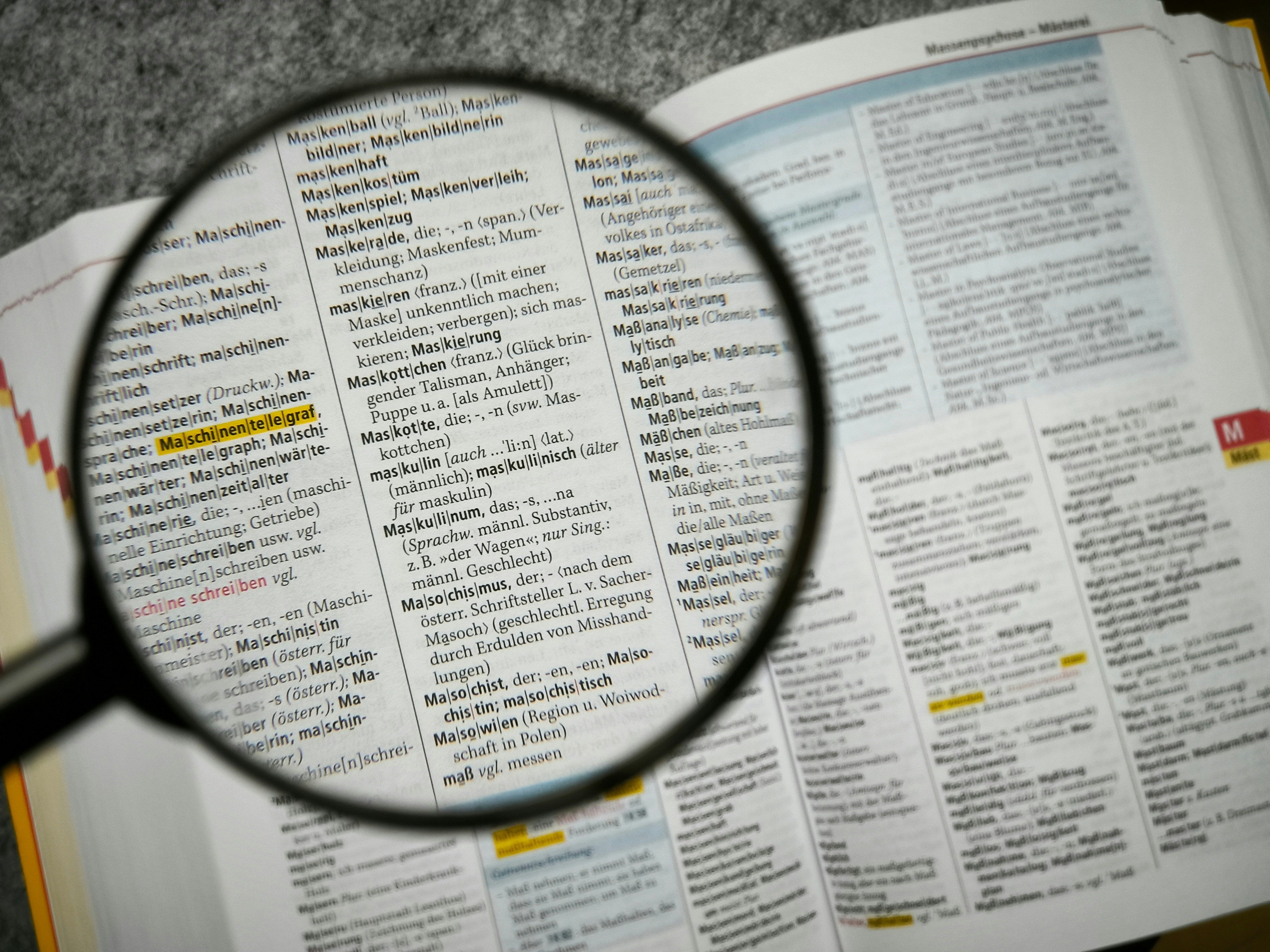 Une loupe survolant un document financier, pour symboliser le travail d'audit, de vérification et le souci du détail indispensable en conformité financière.