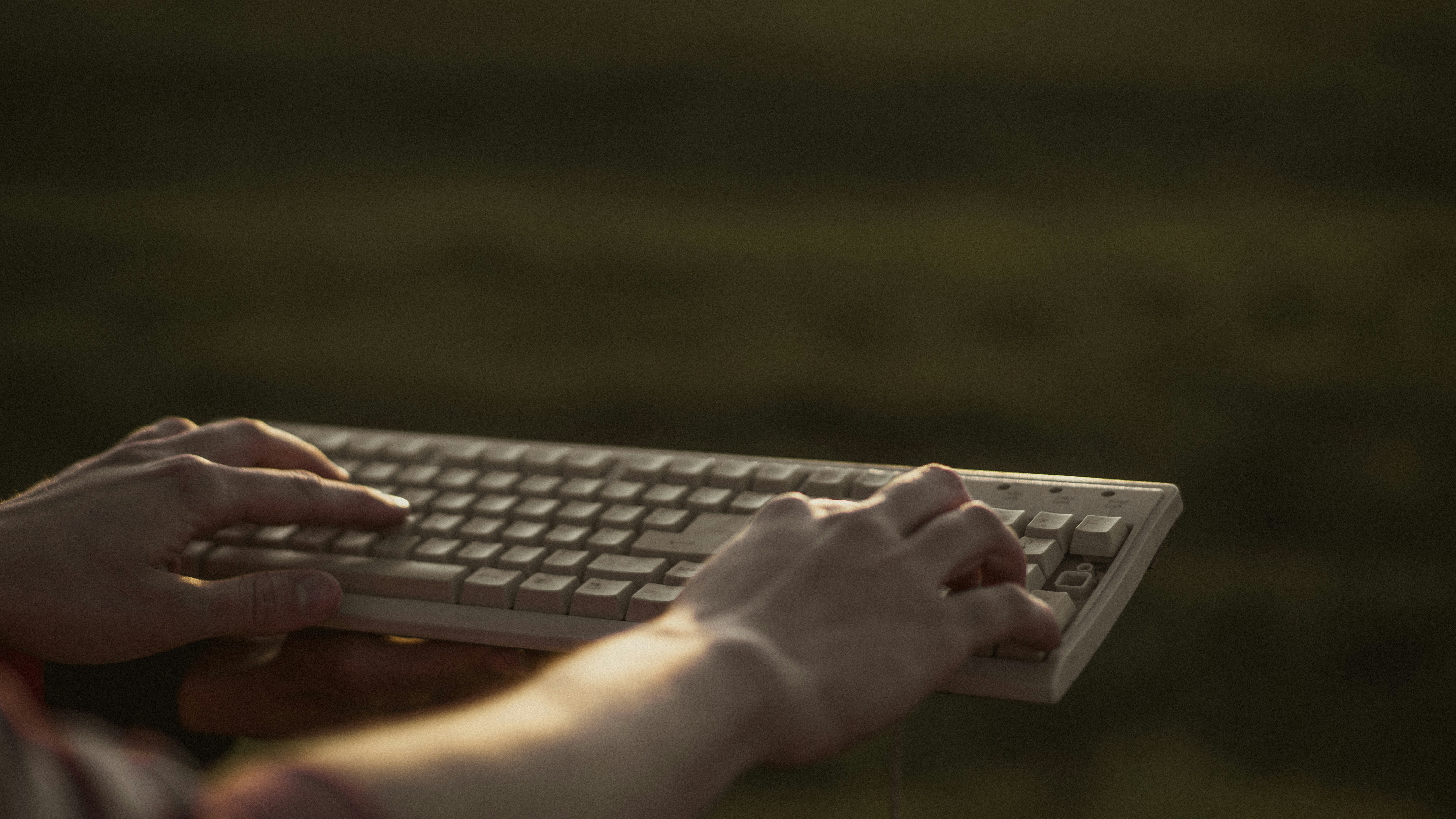 A close-up shot of a keyboard with a person's hands typing, a cup of coffee nearby, suggesting a productive content creation session.