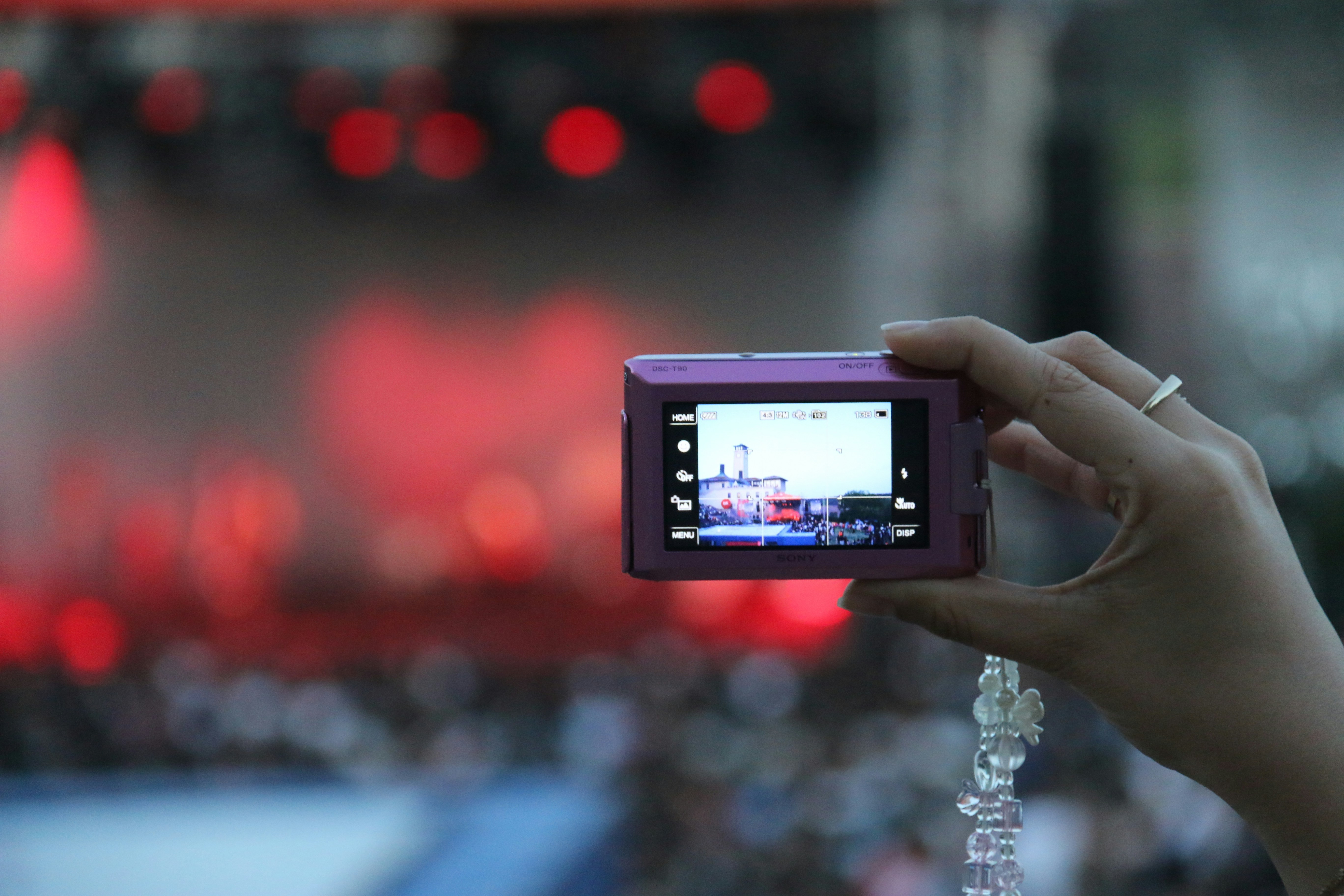 A well-organized merchandise table at a concert, with t-shirts, posters, and a small, stylish sign with a QR code on it.
