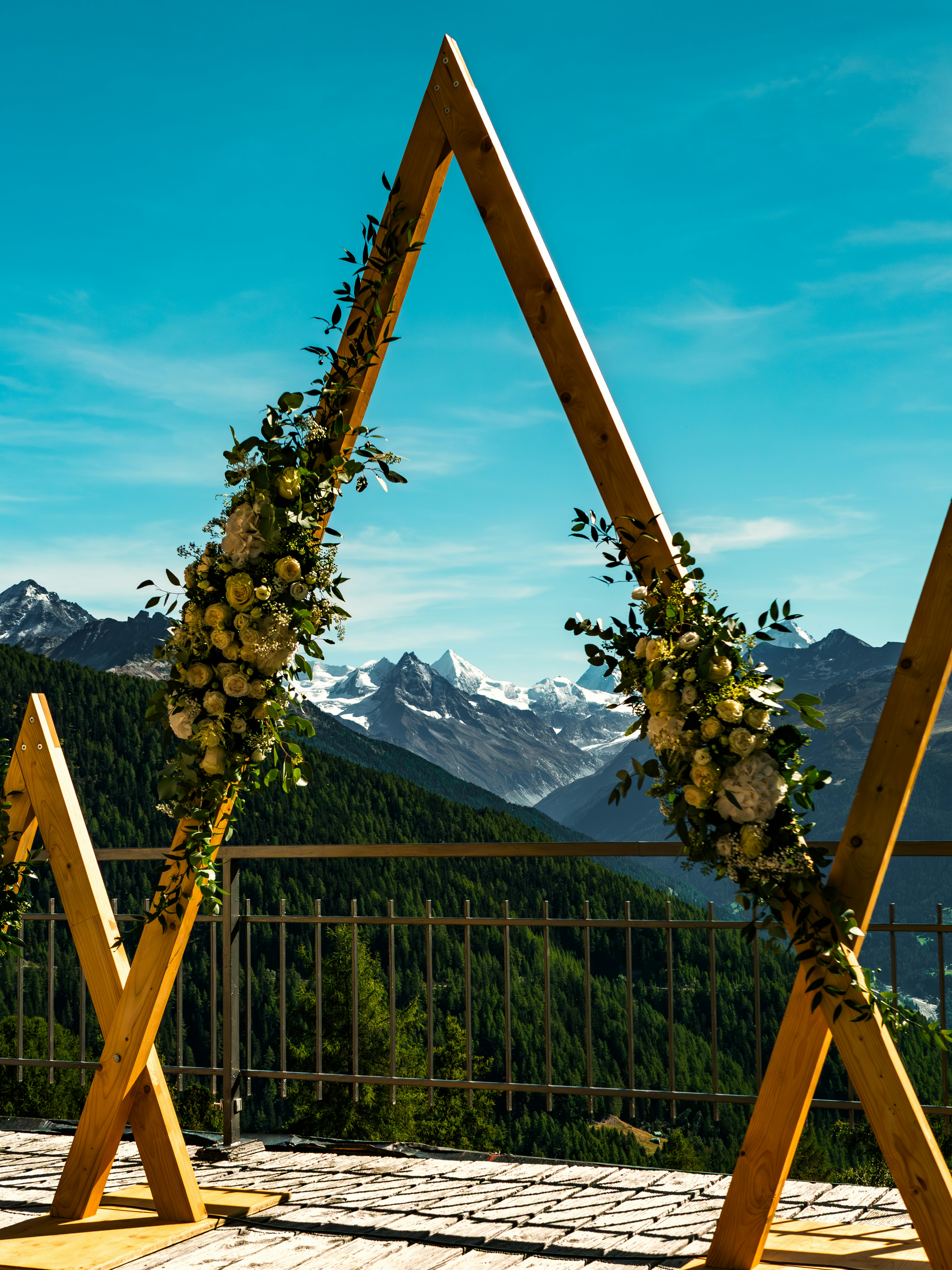 Paysage de mariage suisse idyllique avec un lac alpin et des montagnes en arrière-plan sous un ciel clair.