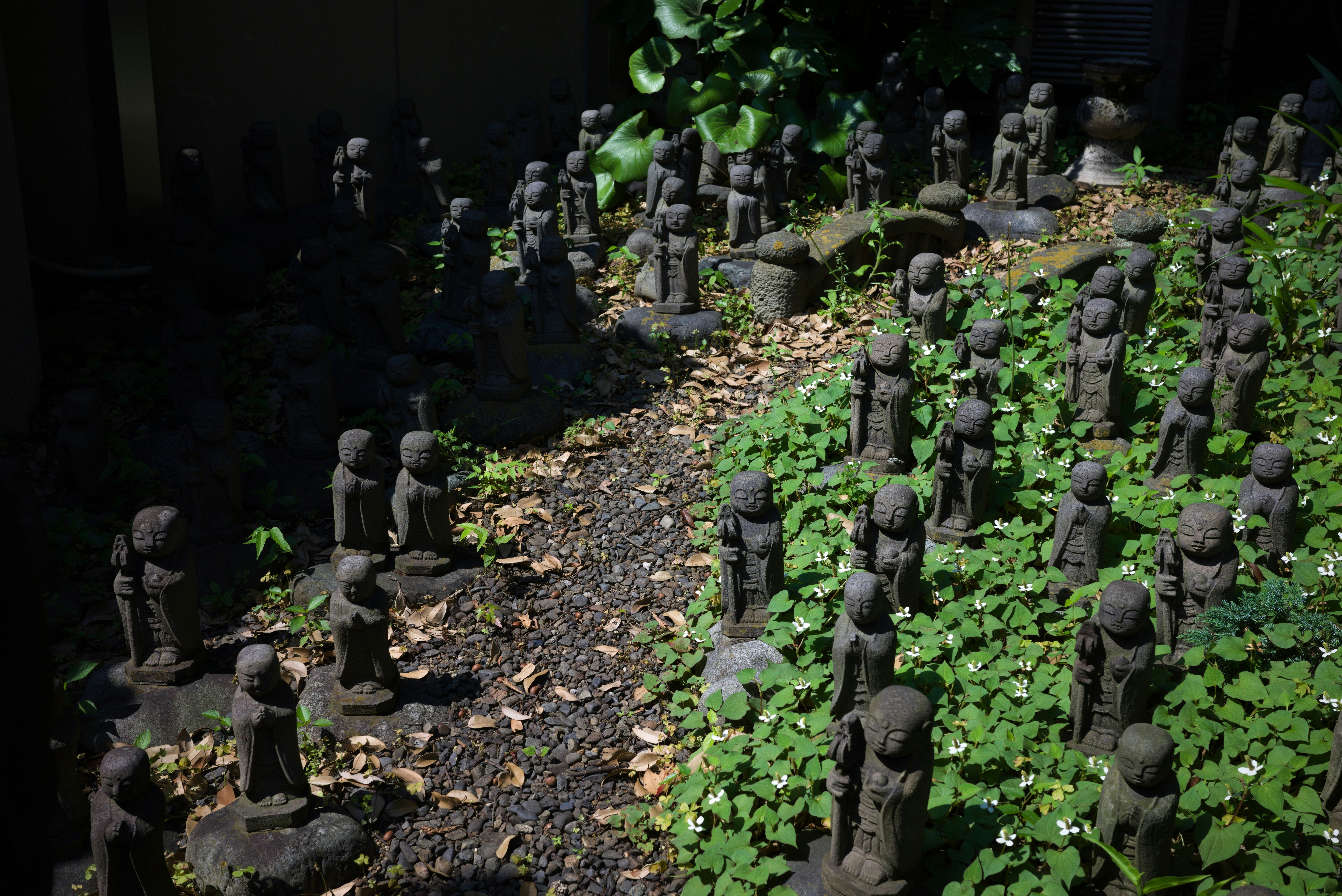 Des pierres de basalte noires empilées les unes sur les autres dans un jardin zen, symbolisant l'équilibre et l'harmonie.