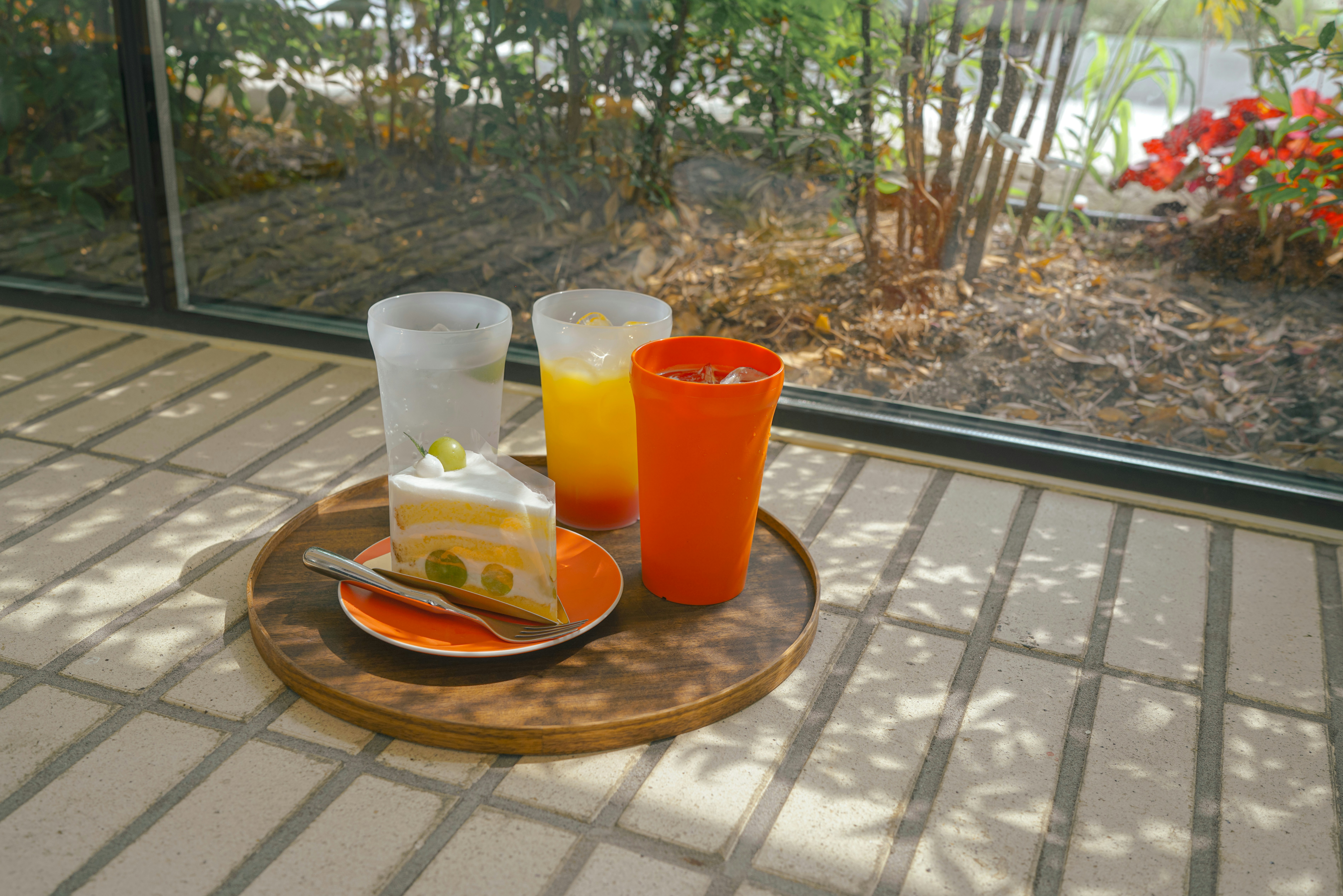 Une table dressée pour le petit-déjeuner avec des sets de table à motifs de citrons, des verres colorés et une carafe avec des tranches d'orange.