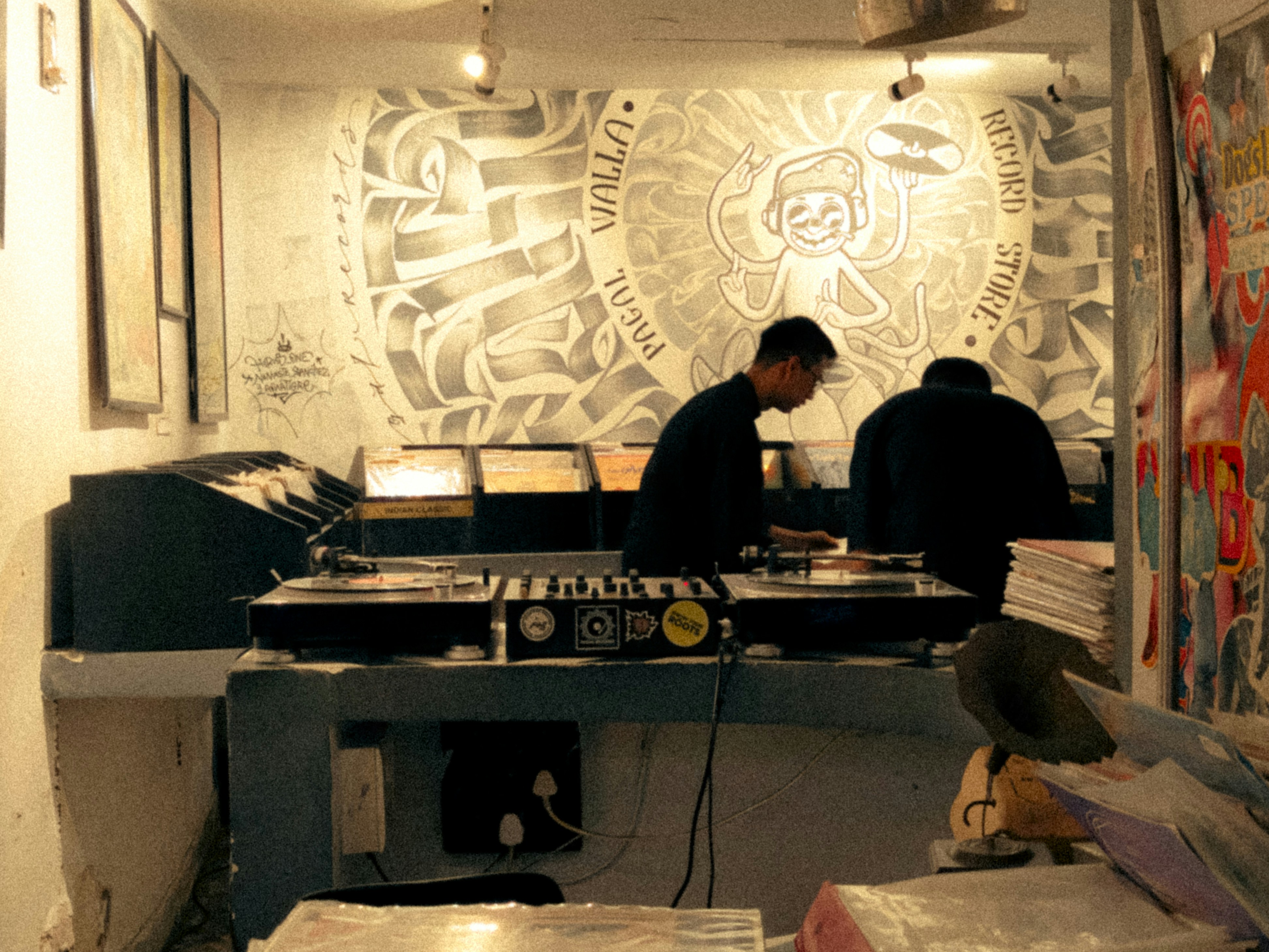 A diverse group of artists—a painter, a musician, and a dancer—collaborating and laughing in a bright, airy studio space.