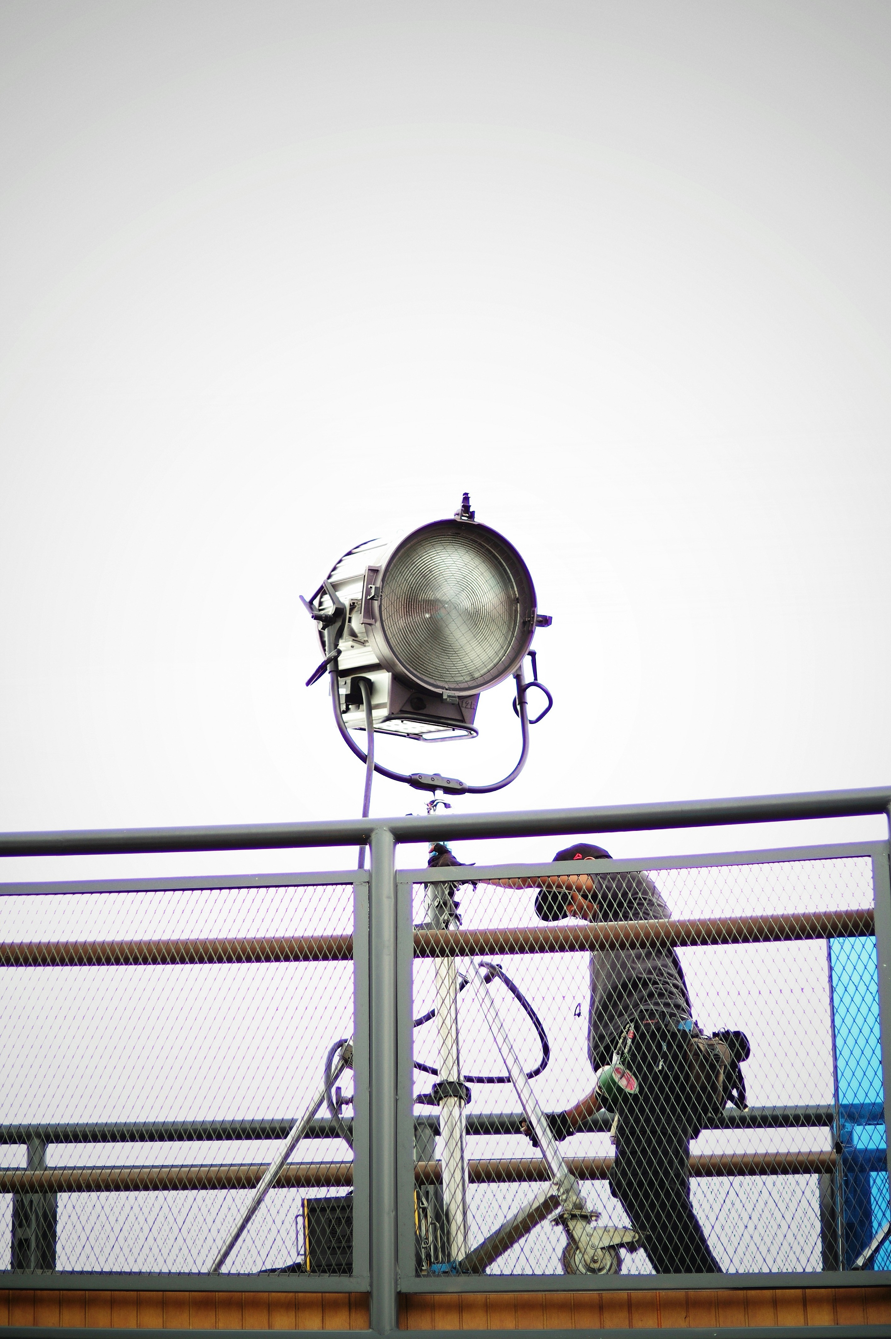 A person's hand holding a smartphone, scanning a QR code on a poster at a live music event. The background is dimly lit and atmospheric.
