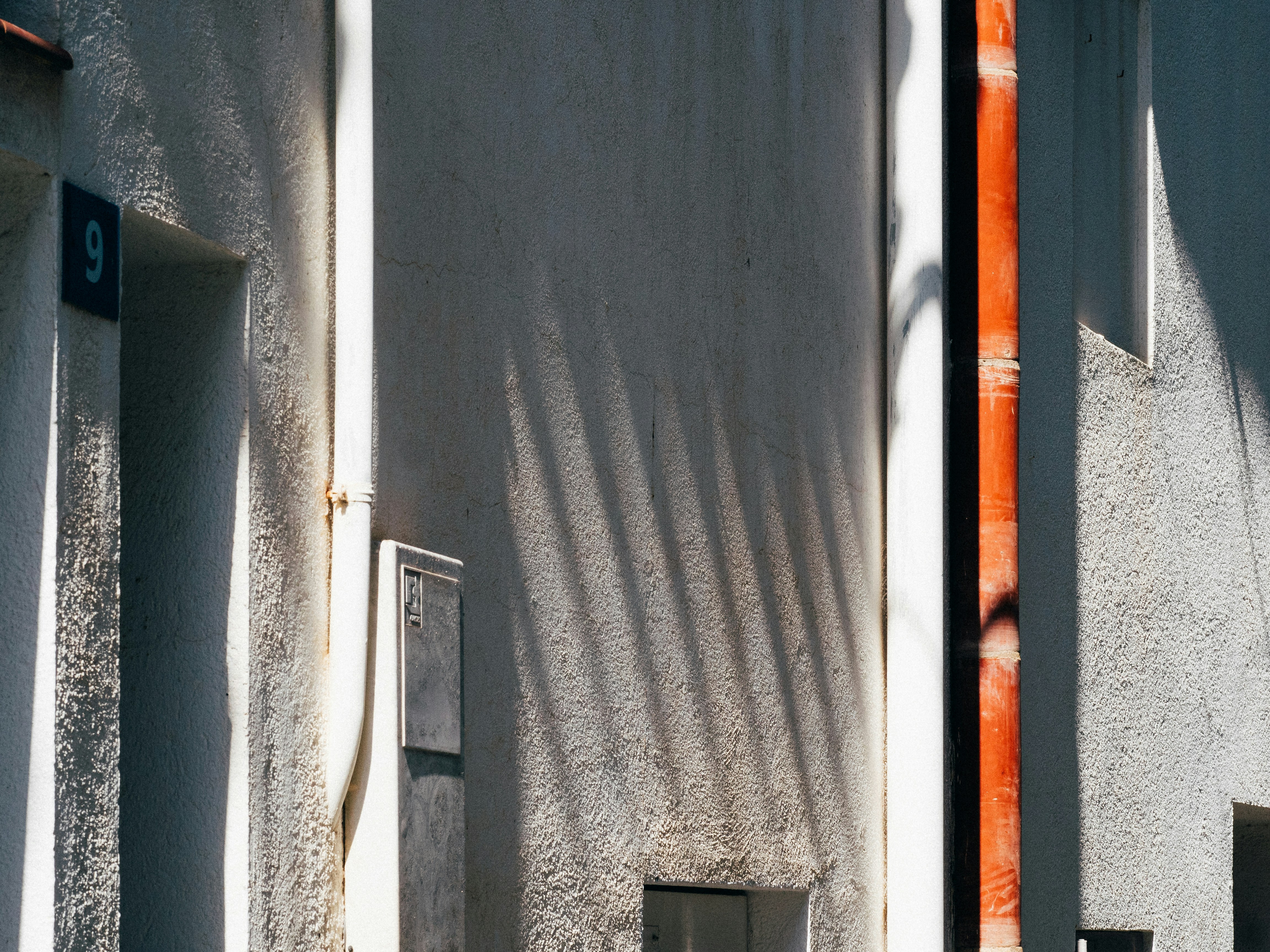 Une personne examinant attentivement un devis détaillé pour des travaux de rénovation de façade, un stylo à la main.