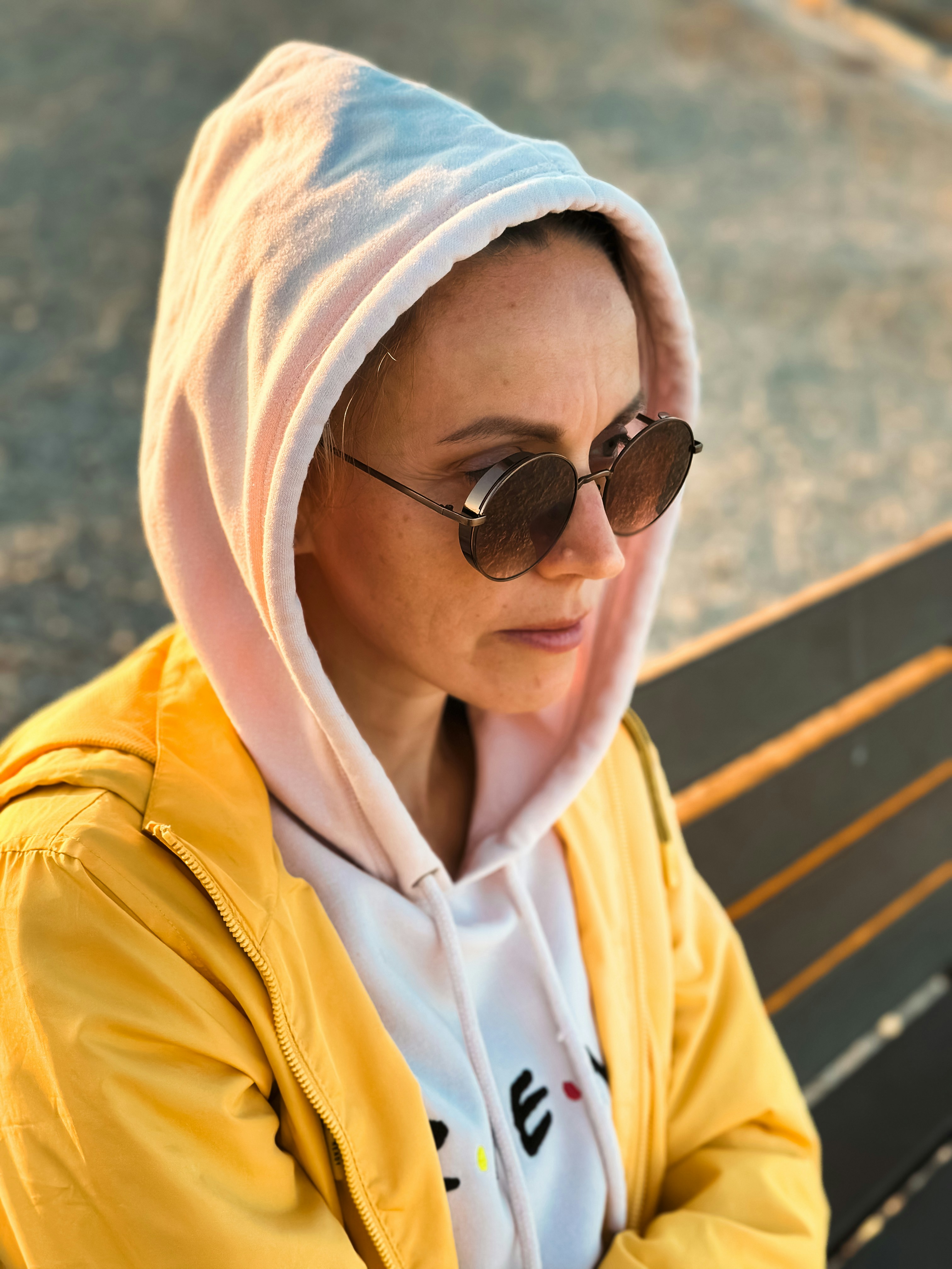 Une femme marchant dans une rue de Los Angeles, portant un jean confortable, un haut simple et un bomber léger, le soleil brillant derrière elle.