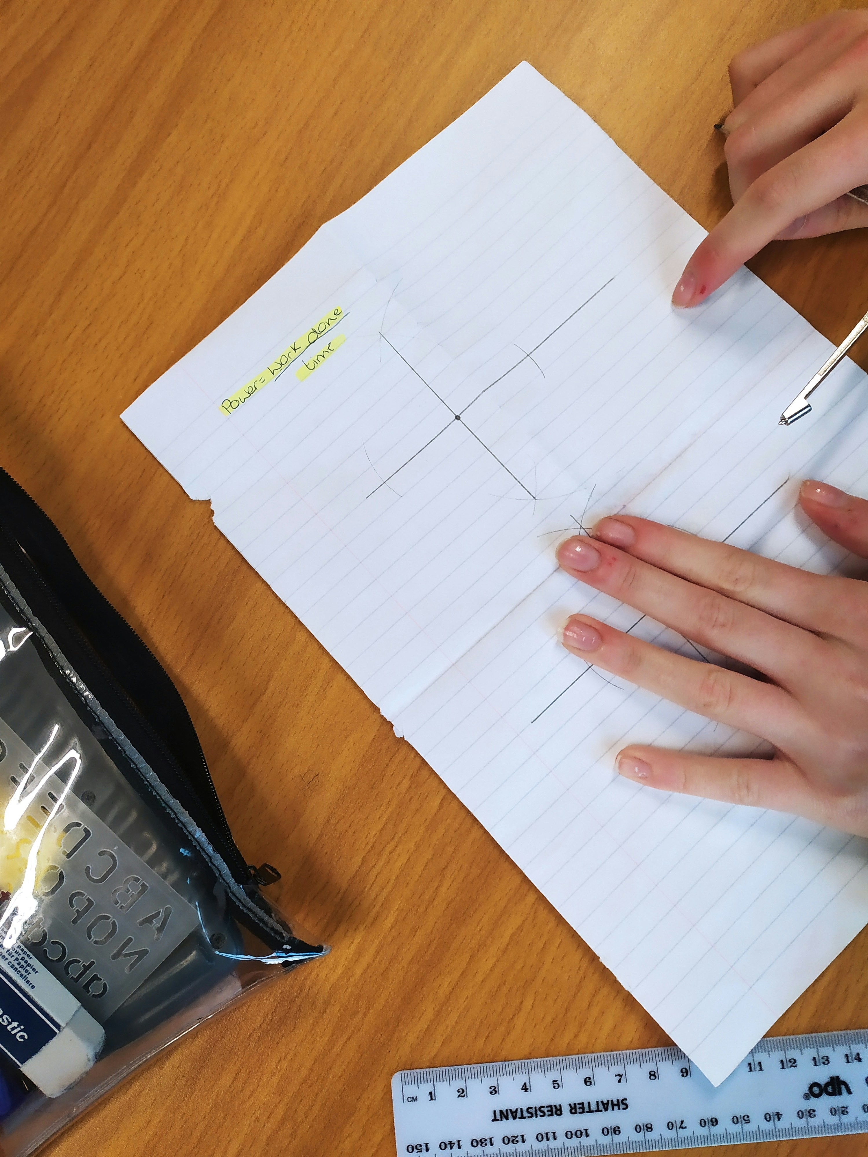 A shot of someone's hands writing in a planner, with a laptop and sticky notes scattered around, perfectly capturing the feeling of strategic planning.