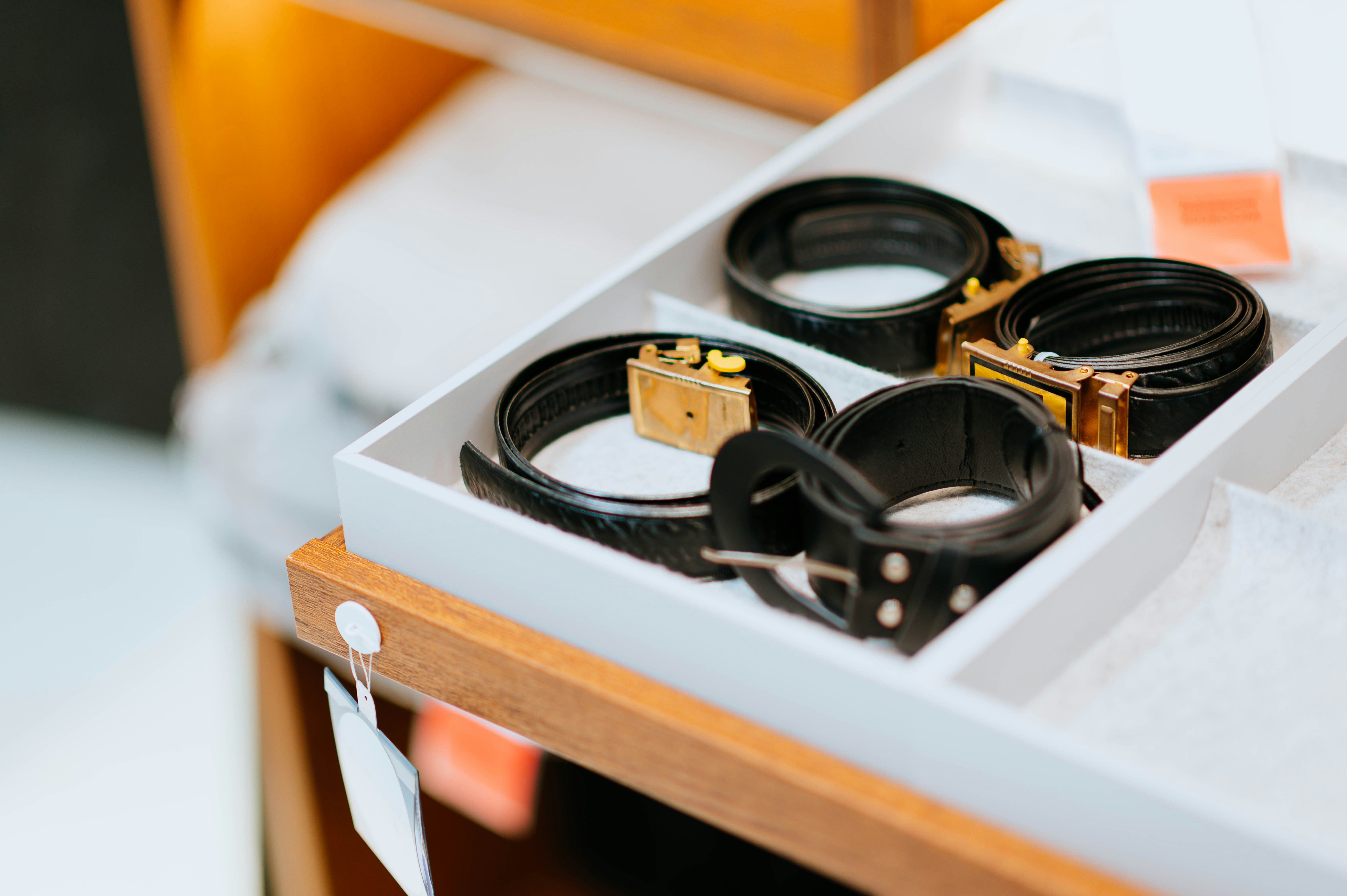 Un accessoire de tiroir de dressing sur mesure avec des séparateurs en velours gris pour organiser des montres, des bijoux et des lunettes de soleil.