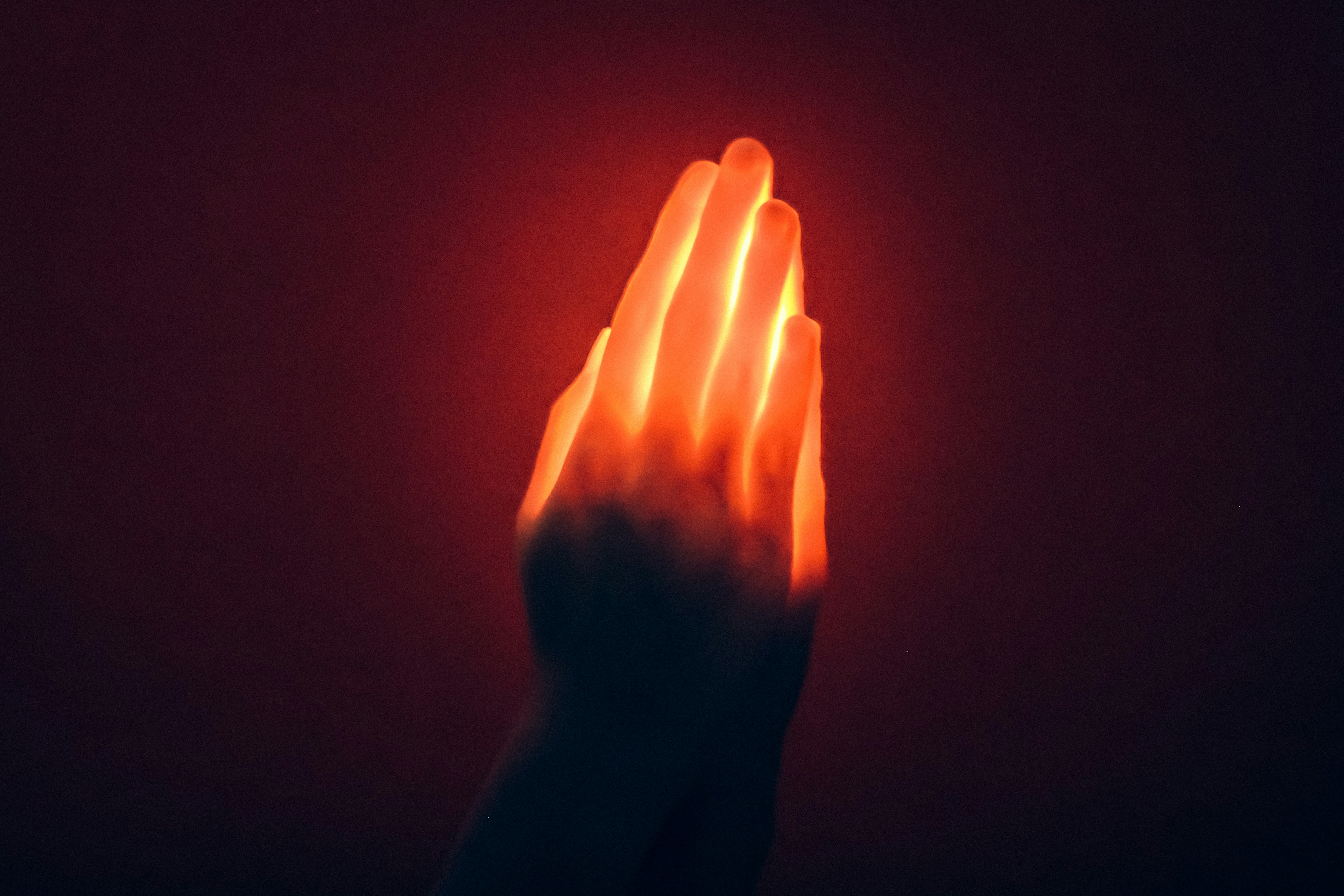 Des mains bienveillantes semblant flotter au-dessus d'une personne allongée, avec des flux de lumière douce symbolisant le transfert d'énergie Reiki.