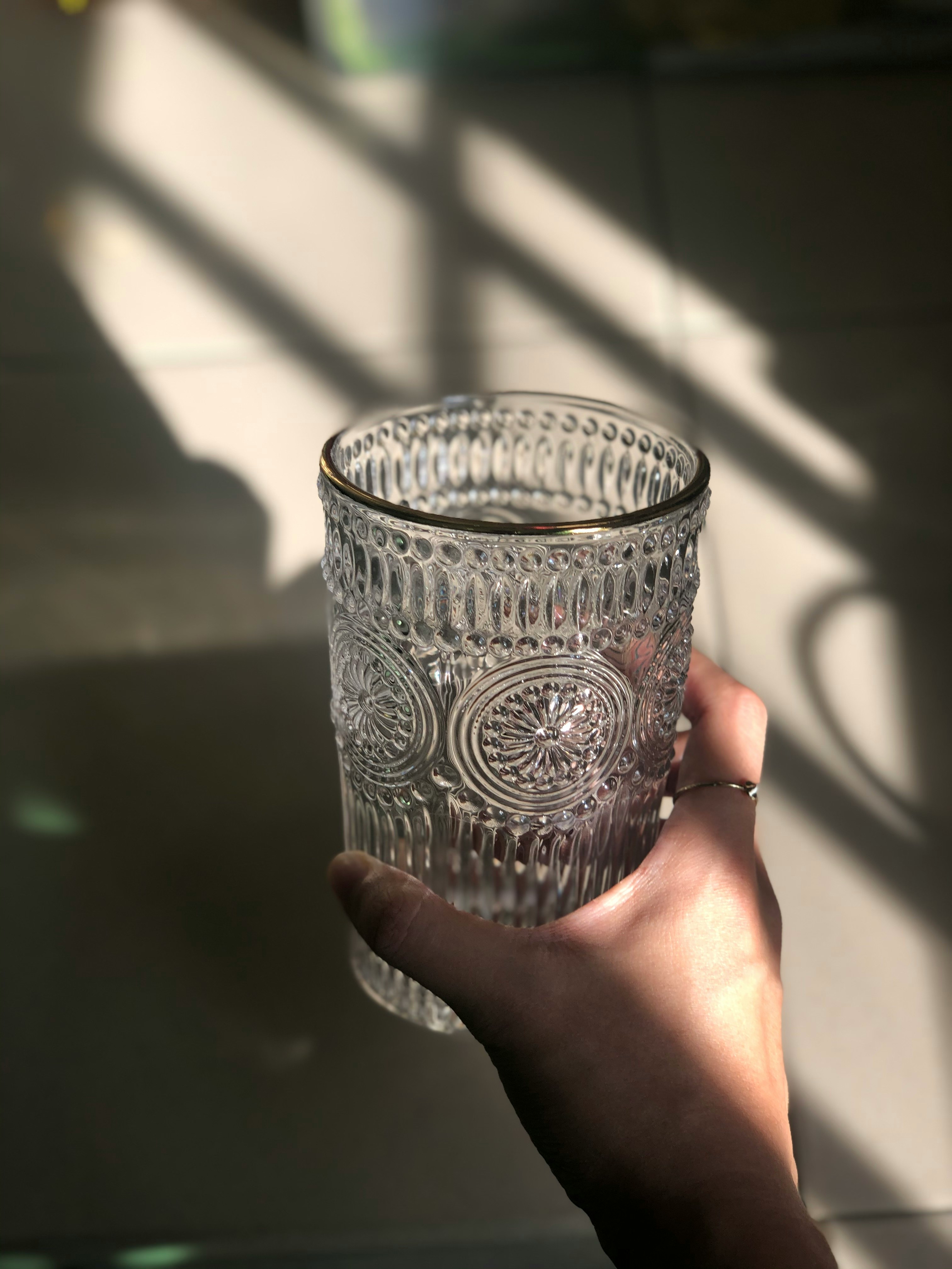 Gros plan d'une bouteille de Grano Maté à côté d'un verre rempli de la boisson pétillante et de glace, sur une table de brunch ensoleillée.